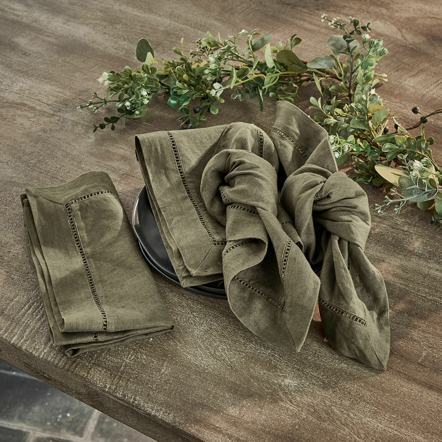 Servet set van 4 Covent Garden Set groene linnen servetten met decoratieve stiksels op houten tafel met plantenversiering