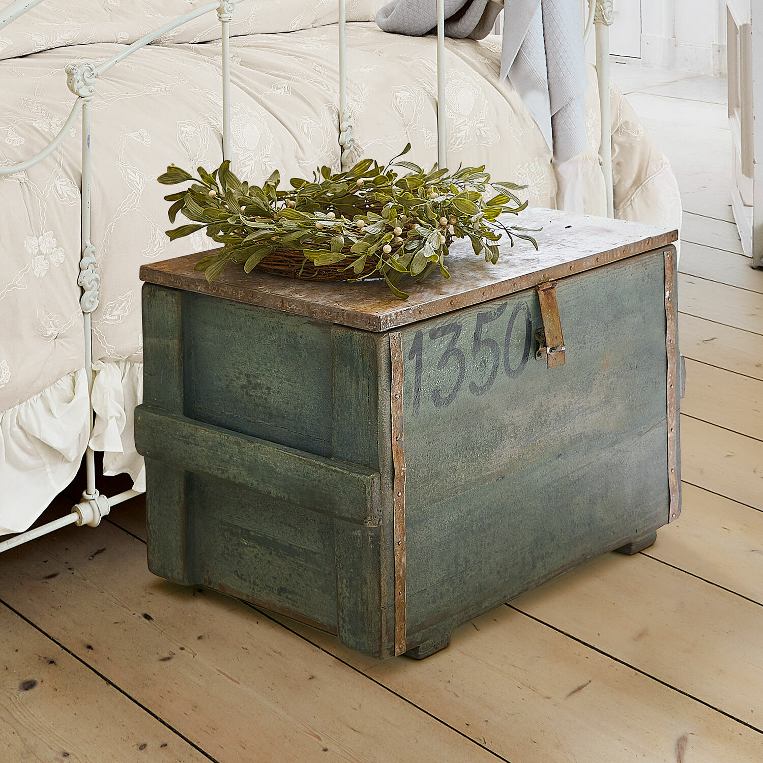 Kist Lorive Groene metalen kist met nummer 1350 en groene bladdecoratie op lichte houten vloer