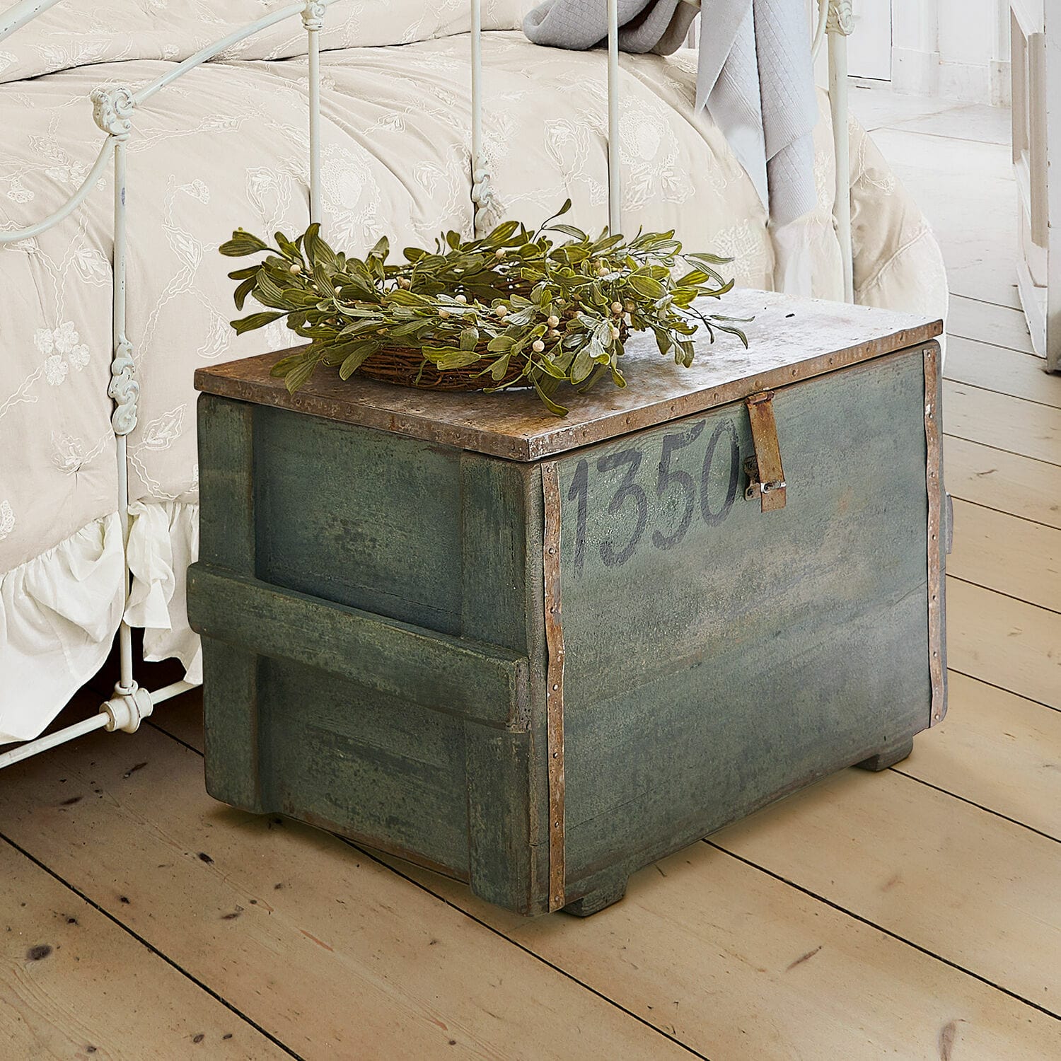 Kist Lorive Groene metalen kist met nummer 1350 en groene bladdecoratie op lichte houten vloer