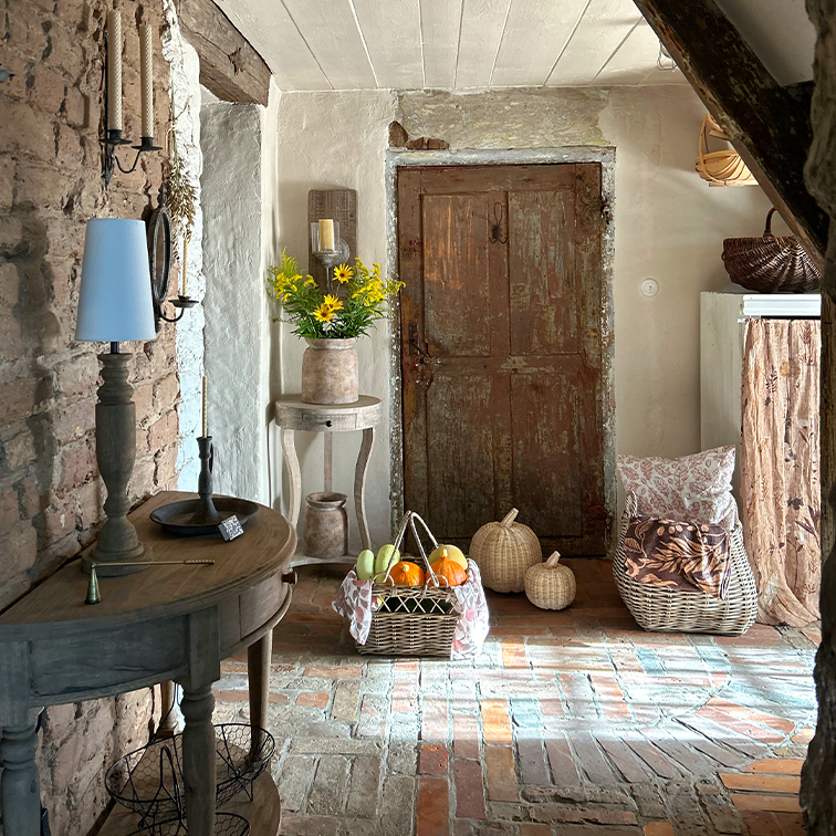 Intérieur rustique avec table en bois, panier en osier rempli de fruits et porte ancienne en bois