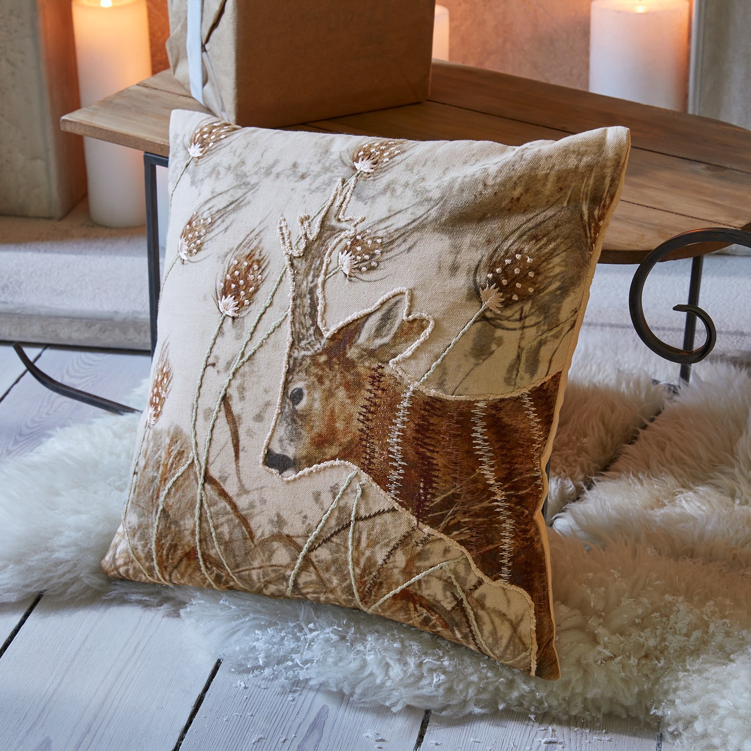 Coussin beige en lin avec broderie de cerf et motif végétal pour décoration intérieure