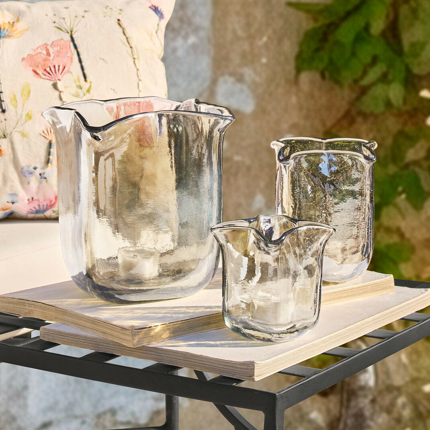 Lot de 3 photophores Ilomiane Ensemble de trois photophores en verre transparent aux formes irrégulières posés sur des livres