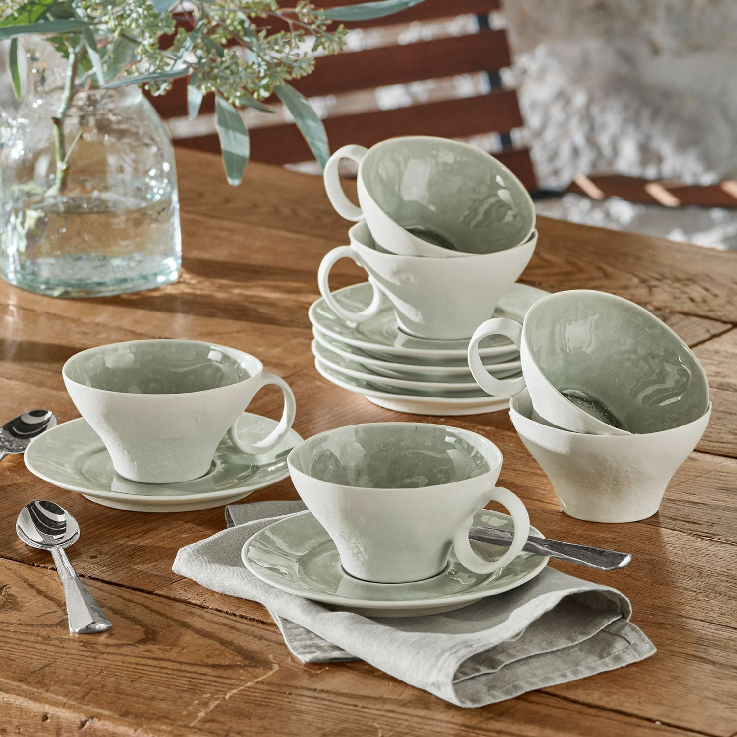 Kopje met schoteltje set van 6 Braganza Set witte keramische kopjes met groene binnenkant op houten tafel met lepels