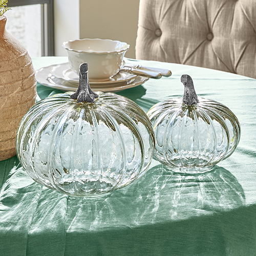 Décorations en verre en forme de citrouilles avec tiges métalliques sur nappe verte, décoration de table