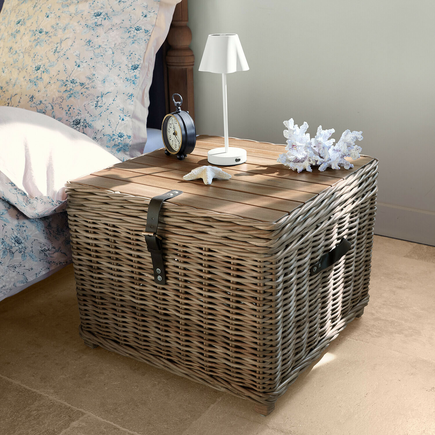 Table de chevet carrée en osier gris avec plateau en bois, lampe blanche et décorations marines