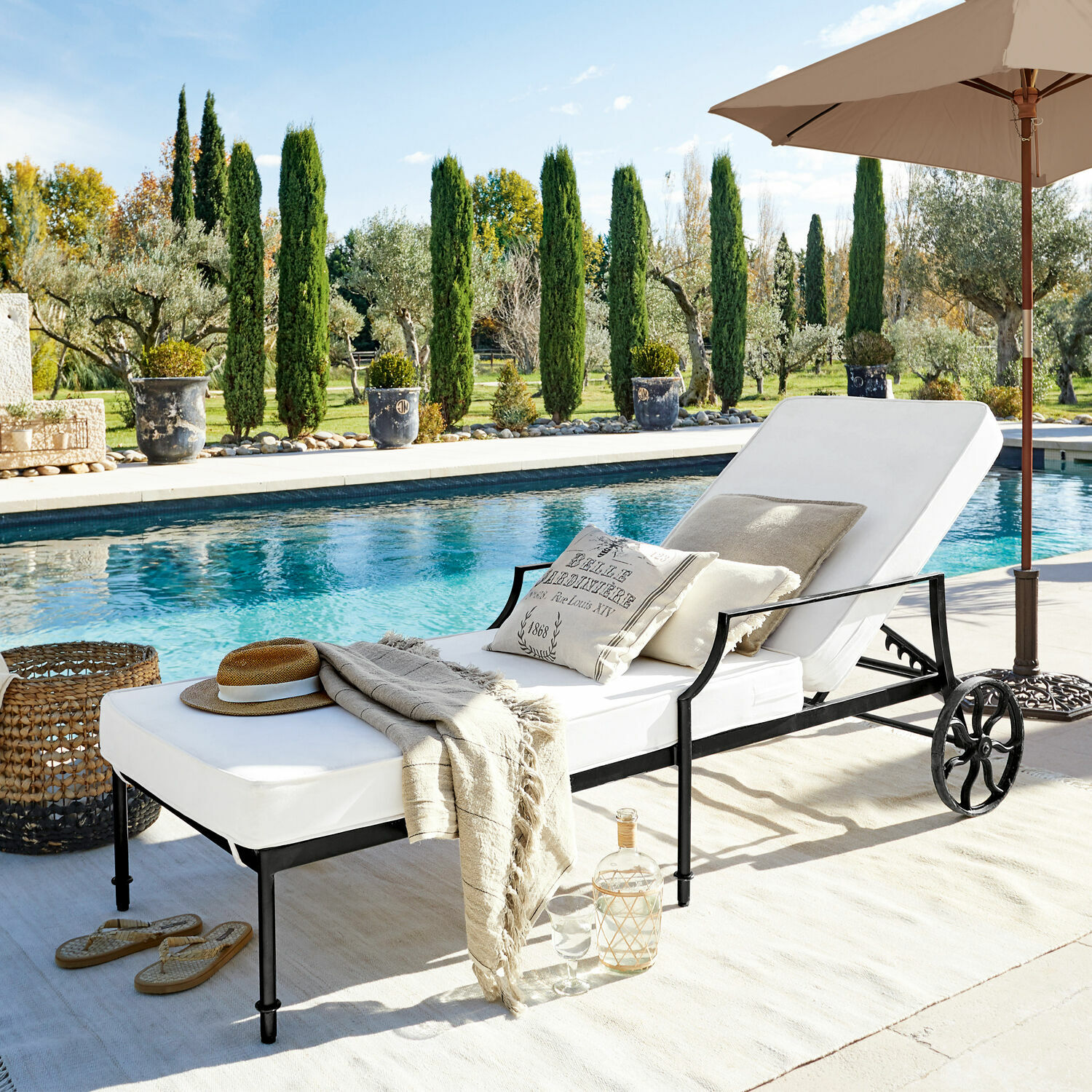 Chaise longue Vienne Chaise longue de jardin avec coussin blanc et cadre en métal noir au bord de la piscine en plein soleil