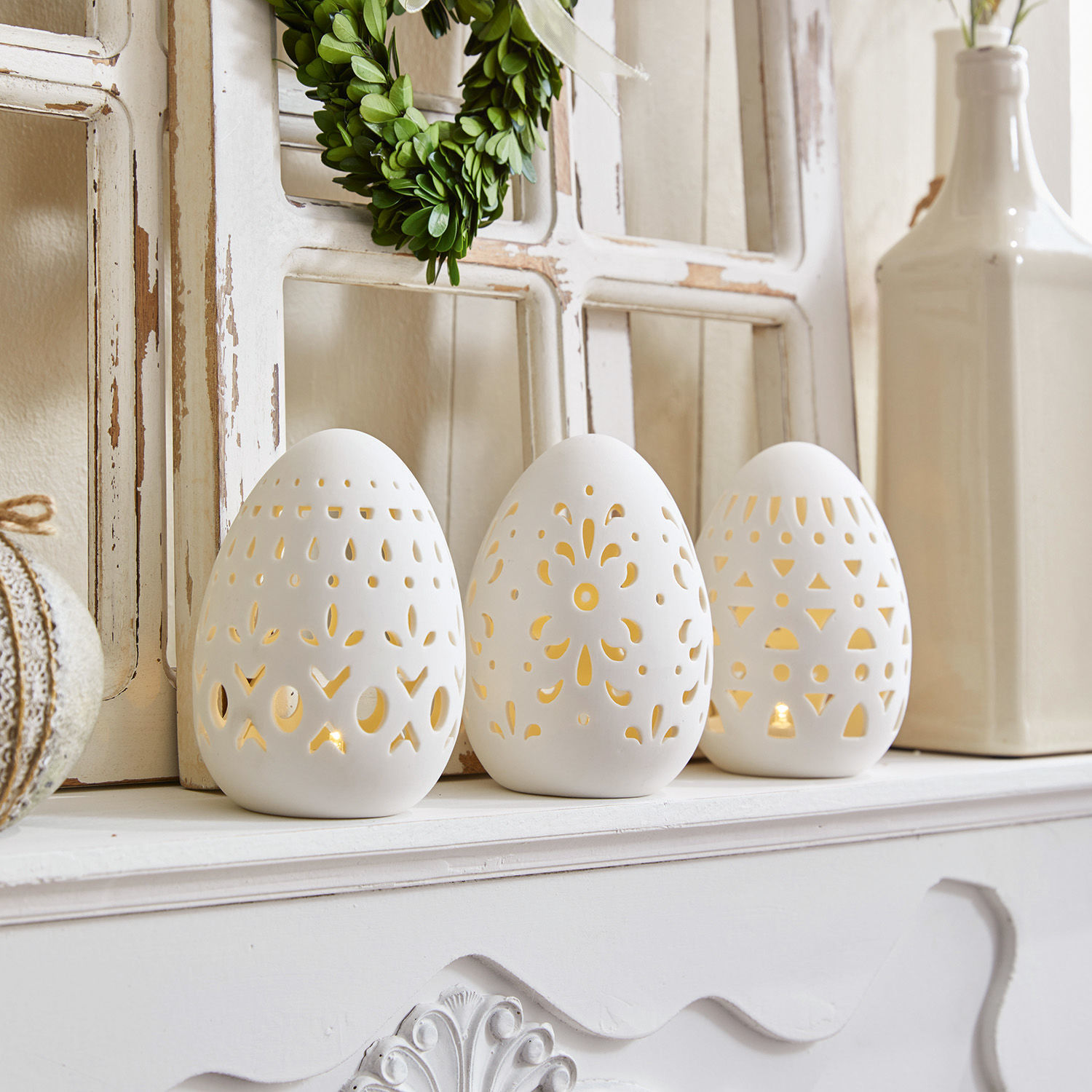 Lot de 3 œufs de Pâques Mouna Ensemble de trois photophores en céramique blanche en forme d'œufs avec motifs ajourés sur cheminée