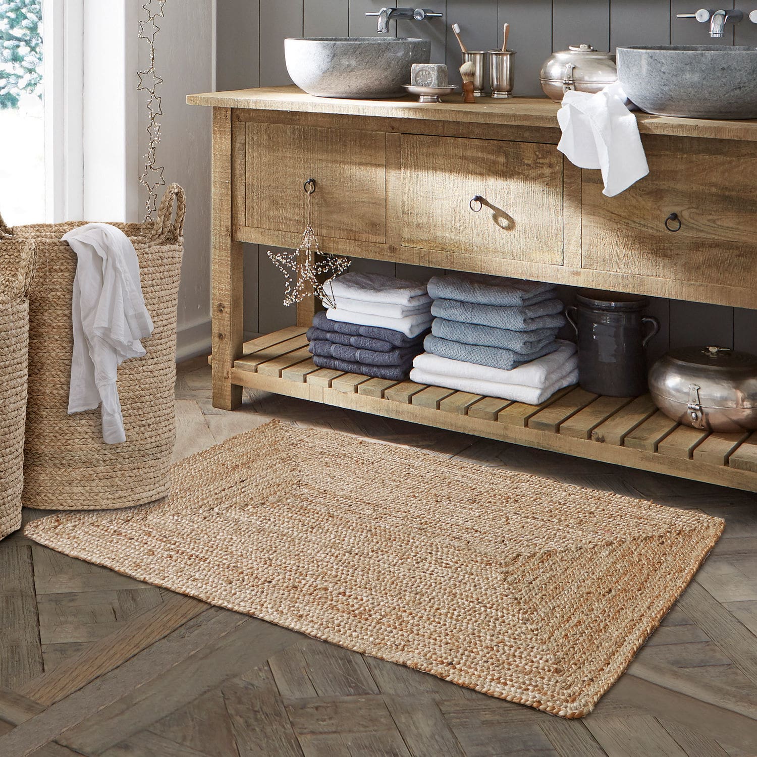 Badmat Busselton Beige badmat van natuurlijke jute op houten vloer naast gevlochten wasmand