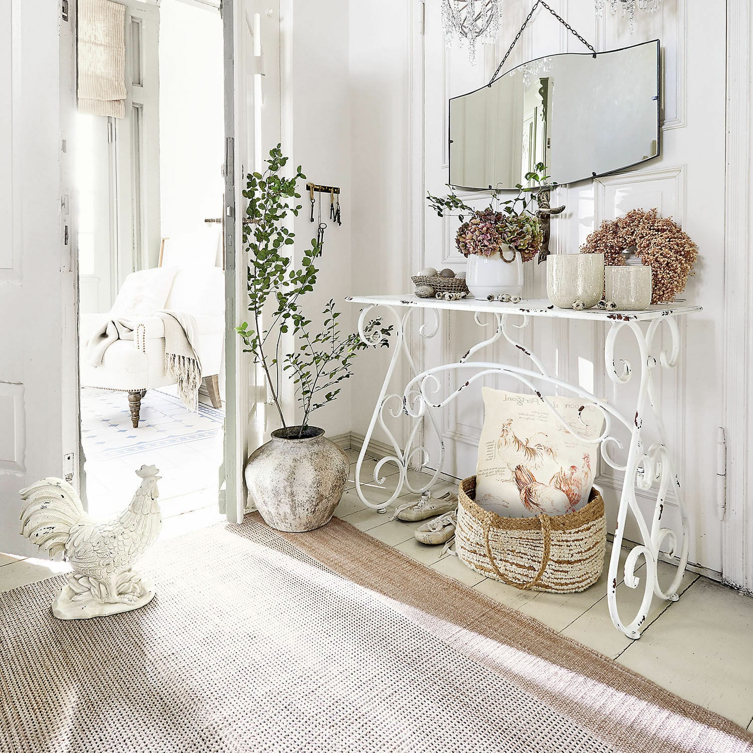 Witte metalen vintage stijl console in lichte kamer met spiegel en groene planten als decoratie
