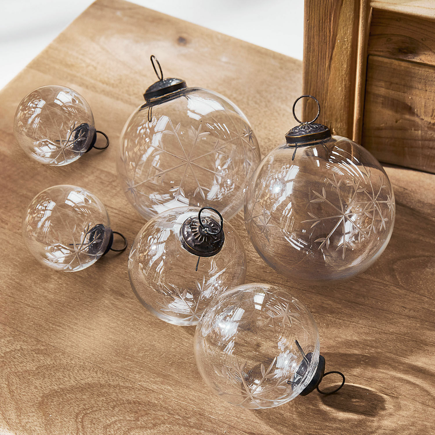 Kerstversiering set van 6 Coro Set transparante glazen kerstballen met gegraveerd sneeuwvlokpatroon op houten achtergrond