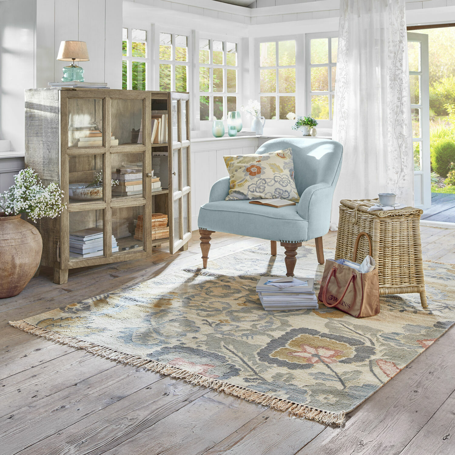Tapis Sussex Fauteuil bleu clair avec pieds en bois sur tapis à motifs dans un salon lumineux avec lumière naturelle