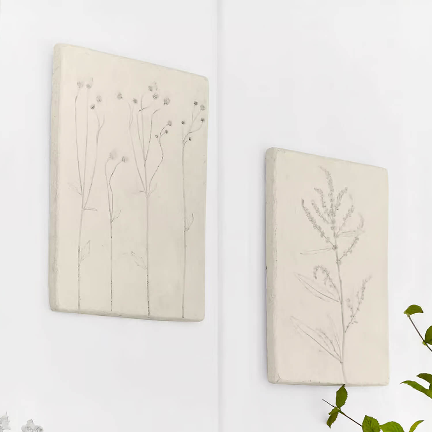 Twee witte wandpanelen met subtiele plantenmotieven voor natuurlijke wanddecoratie