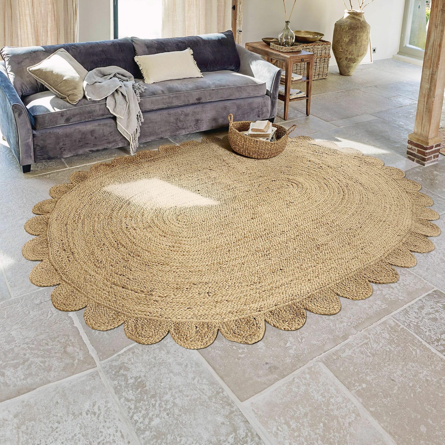 Tapis Ferce Tapis rond en jute couleur naturelle avec bord décoratif dans un salon avec canapé gris