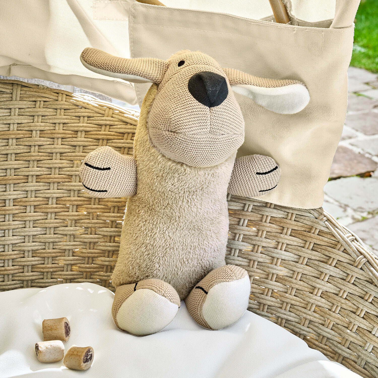 Hondenspeeltje Wuffie Beige knuffel schaap met zachte pluche en gebreide details op een rotan stoel
