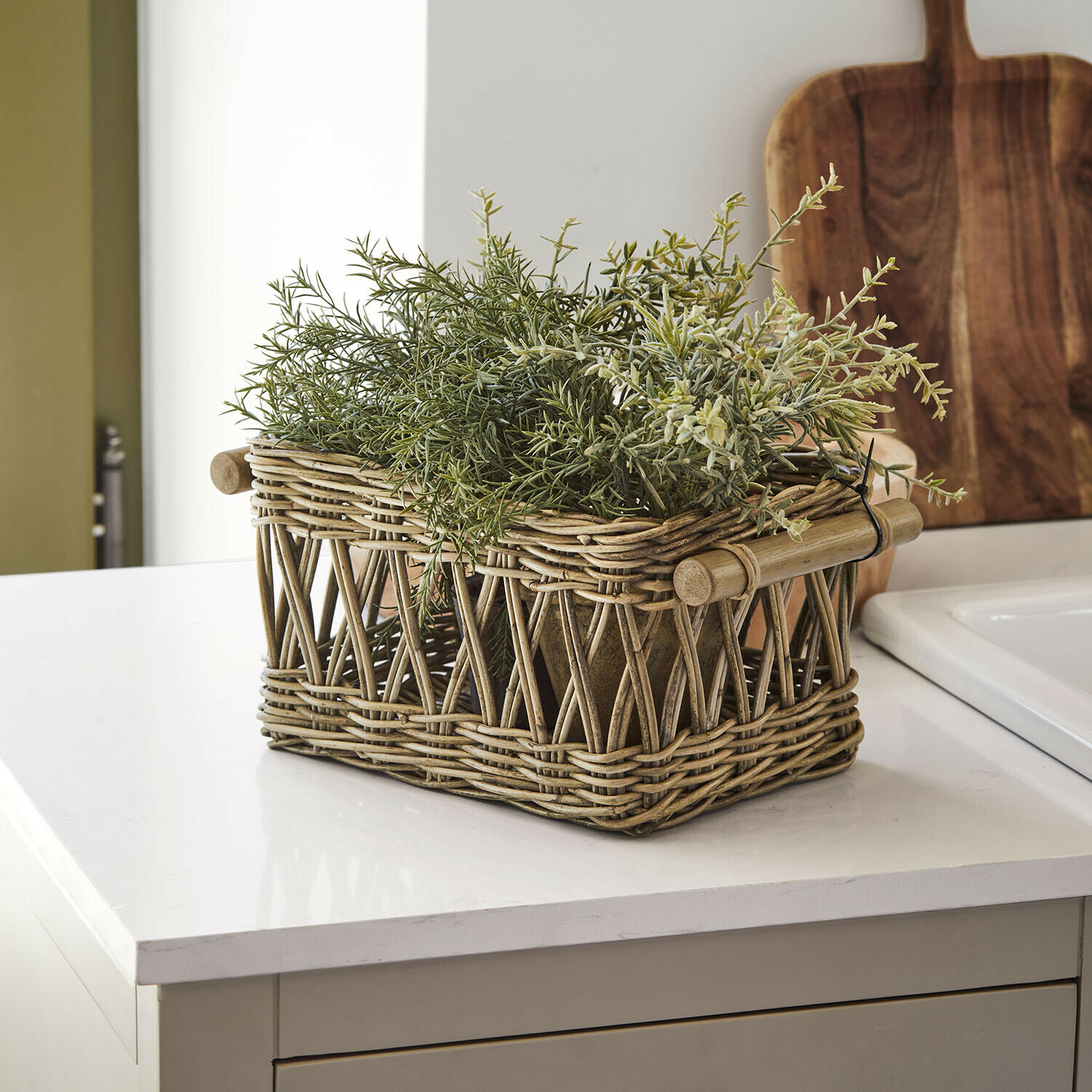 Mand Kettlewells Rustieke mand van natuurlijk riet met groene planten op een modern keukenblad