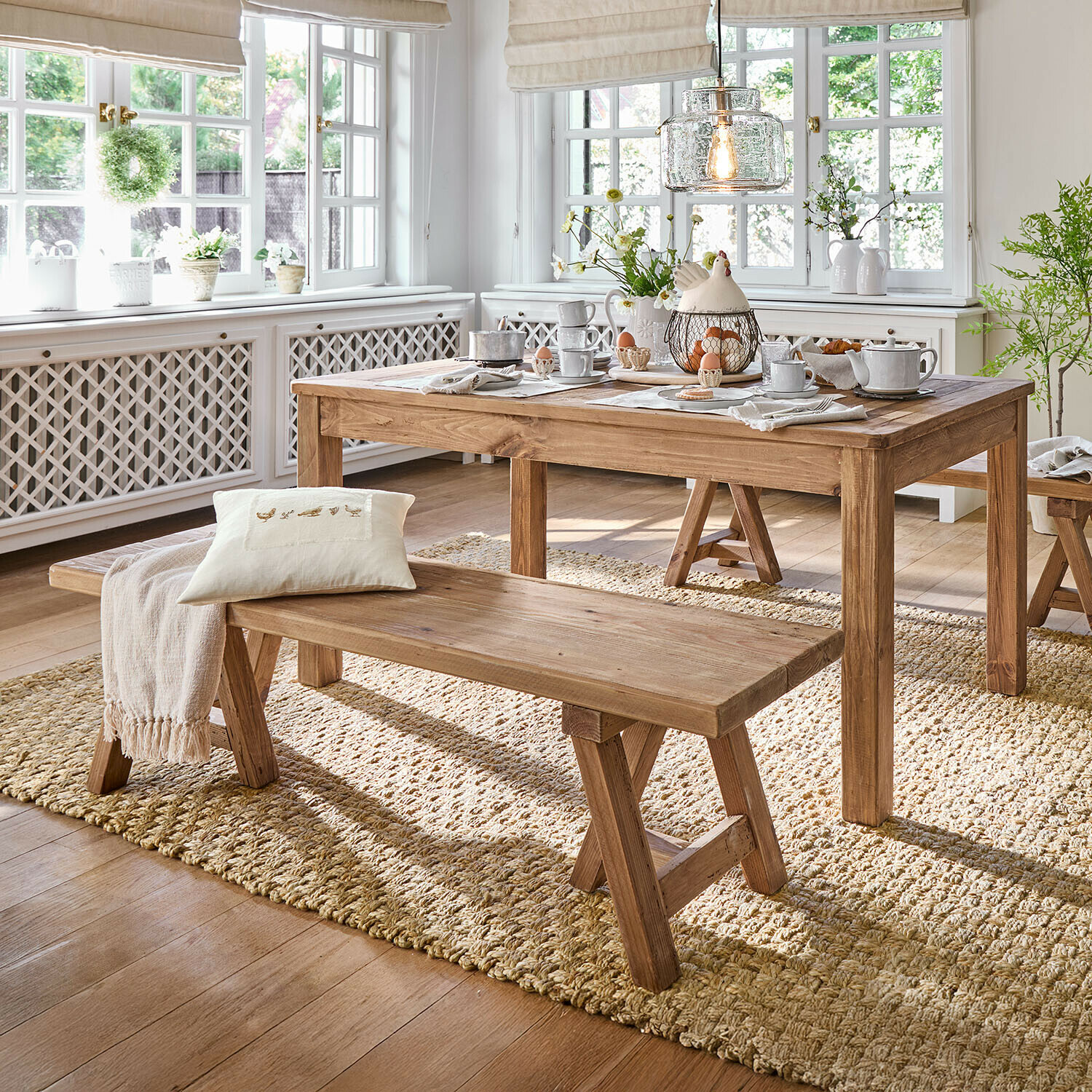 Banc Amherst Salle à manger avec table et banc en bois sur tapis naturel, intérieur lumineux avec grandes fenêtres