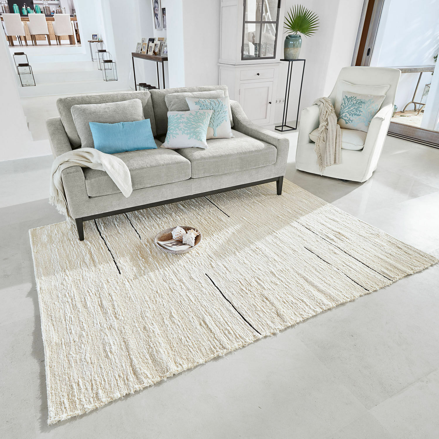 Vloerkleed Avatele Lichtgrijs vloerkleed met subtiel patroon in moderne woonkamer met beige bank en stoelen