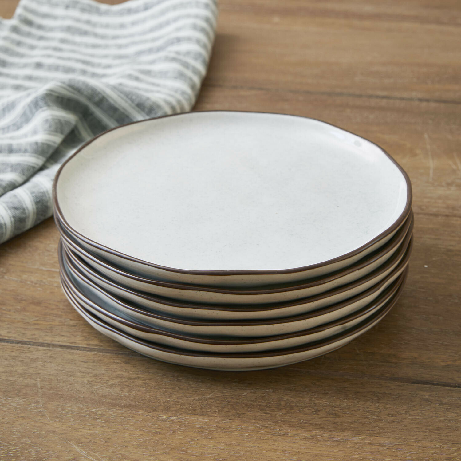 Lot de 6 assiettes à dessert Biarré Ensemble de six assiettes en céramique crème avec bord brun posées sur une table en bois