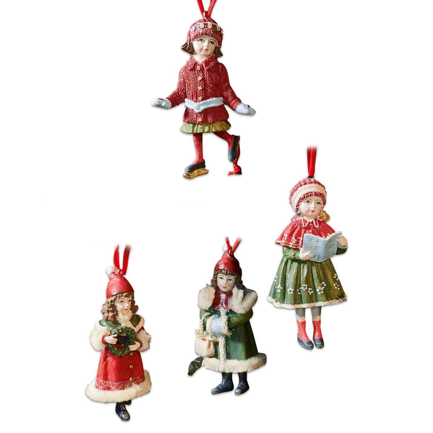 Set van vier kerstboomversieringen met kinderen in rode en groene winterkleding