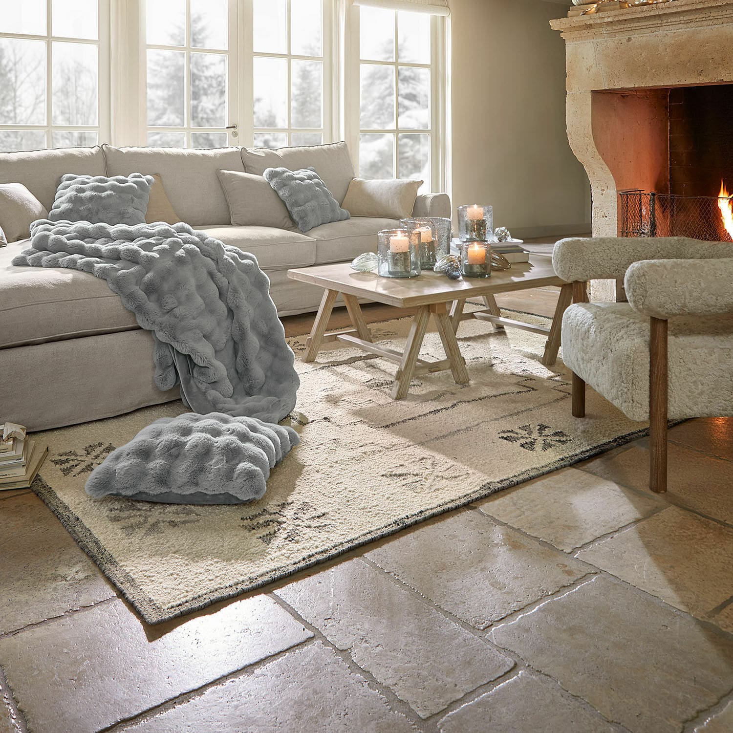 Tapis Xerven Salon chaleureux avec canapé beige, plaid et coussins gris, cheminée allumée et table basse en bois