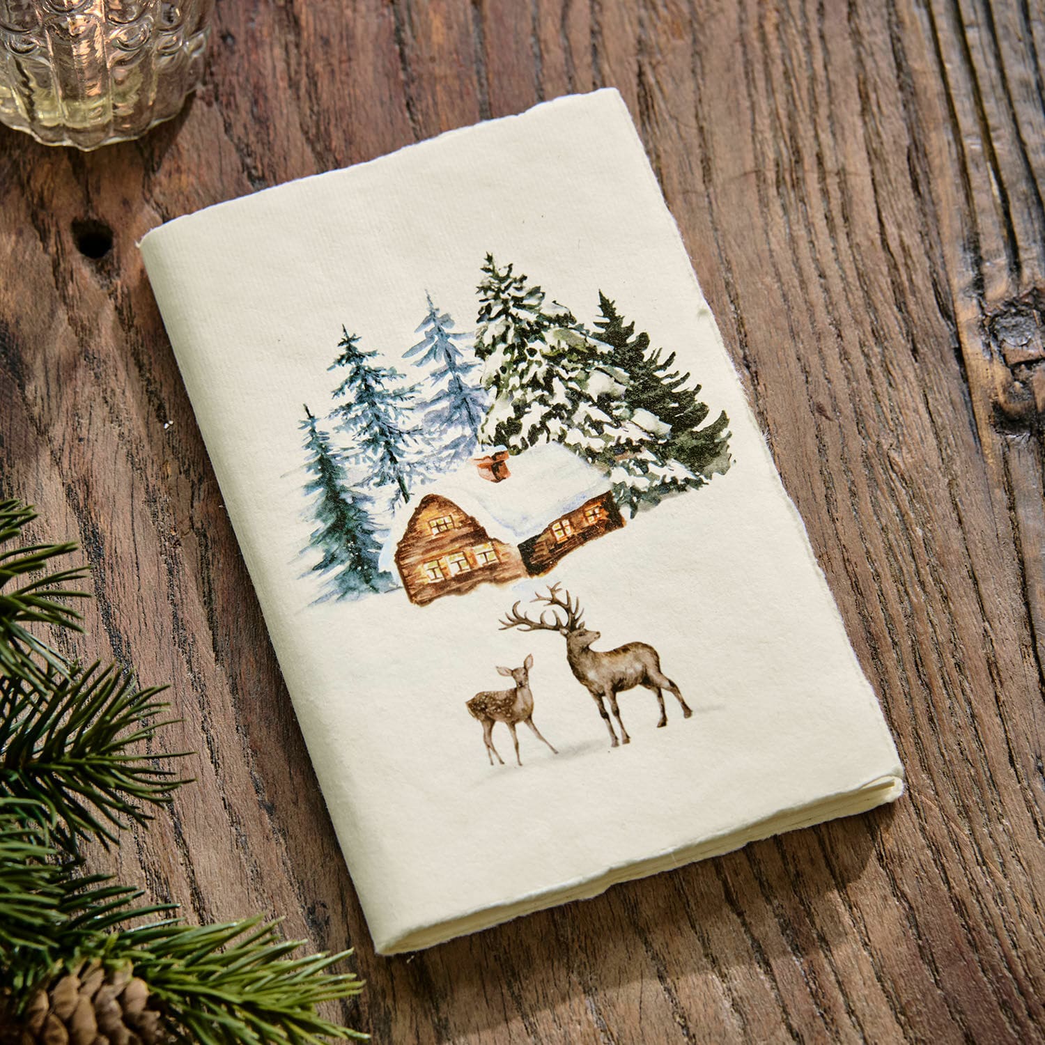 Notitieboekje Lorandis Witte katoenen theedoek met print van besneeuwd huis en herten op houten tafel, winterdecoratie