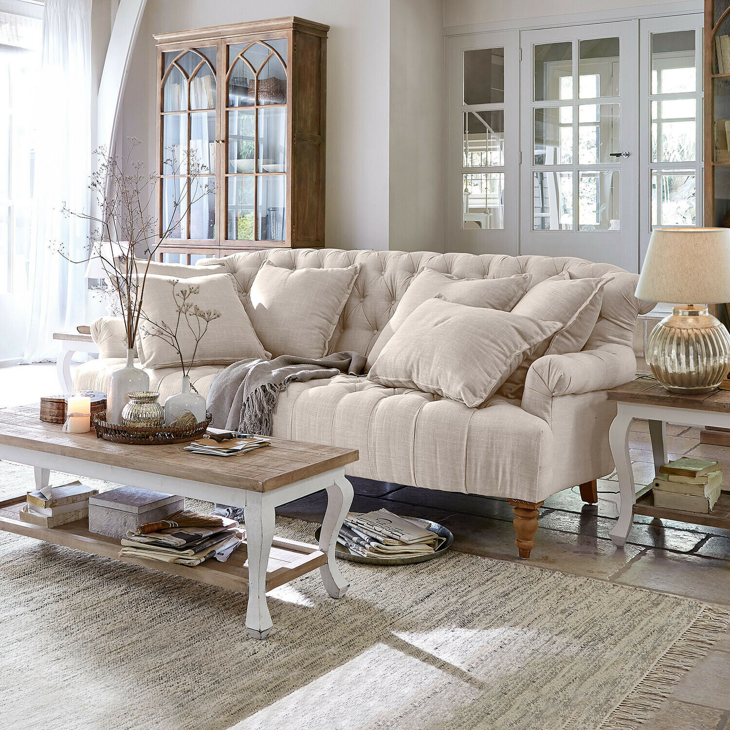 Bank Springfield Village Beige gestoffeerde bank met kussens en houten salontafel in lichte woonkamer