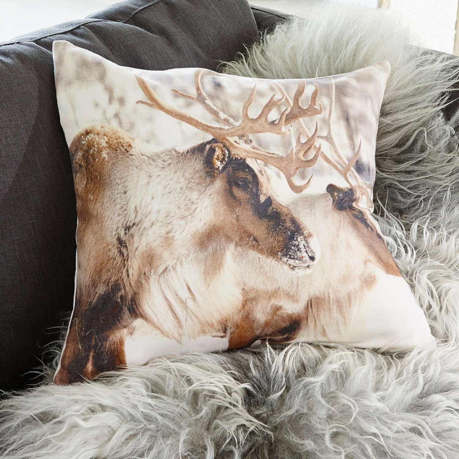 Coussin décoratif avec motif de rennes en tons bruns naturels sur fond clair, tissu doux