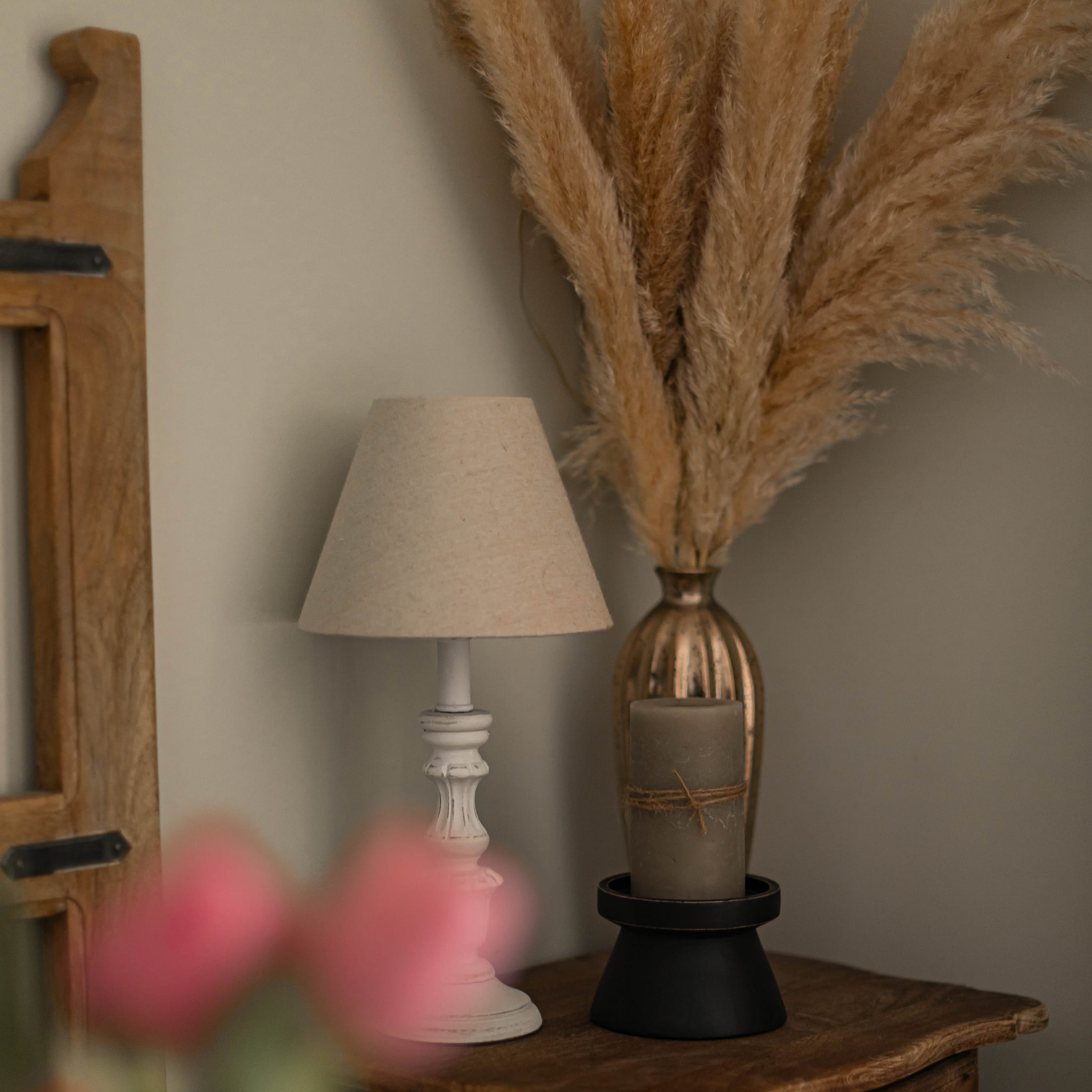Lampe de table en bois blanc avec abat-jour beige sur une table en bois avec décoration en herbe de la pampa