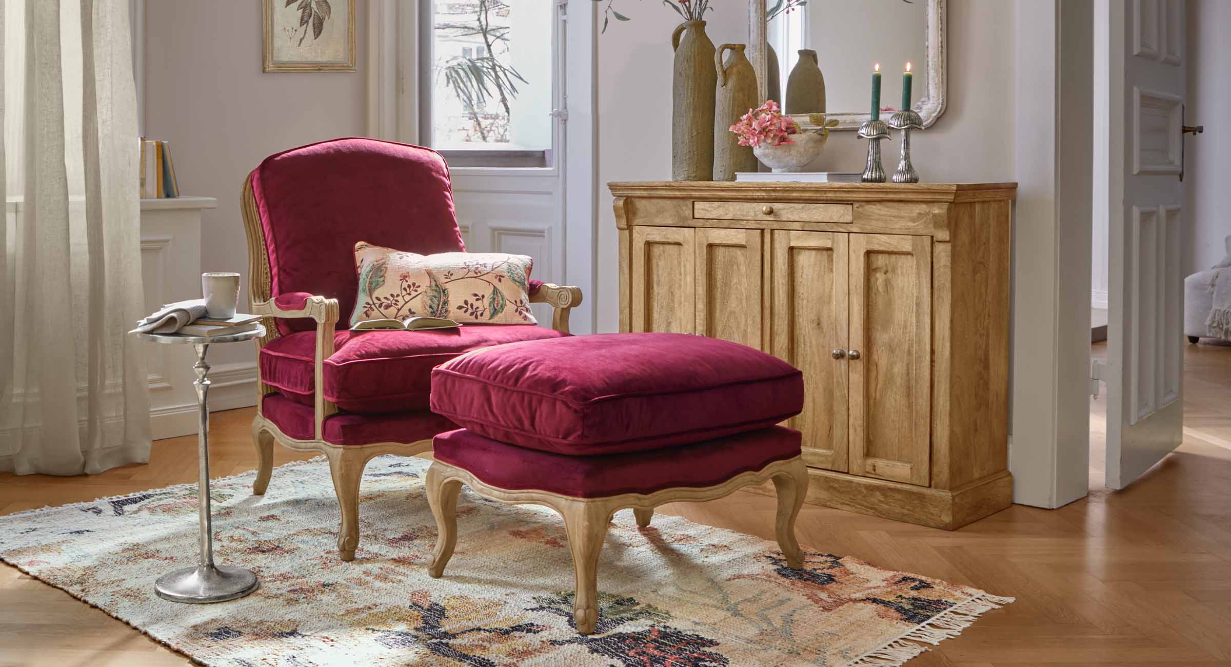 Fauteuil et repose-pieds en velours bordeaux avec cadre en bois dans un salon classique