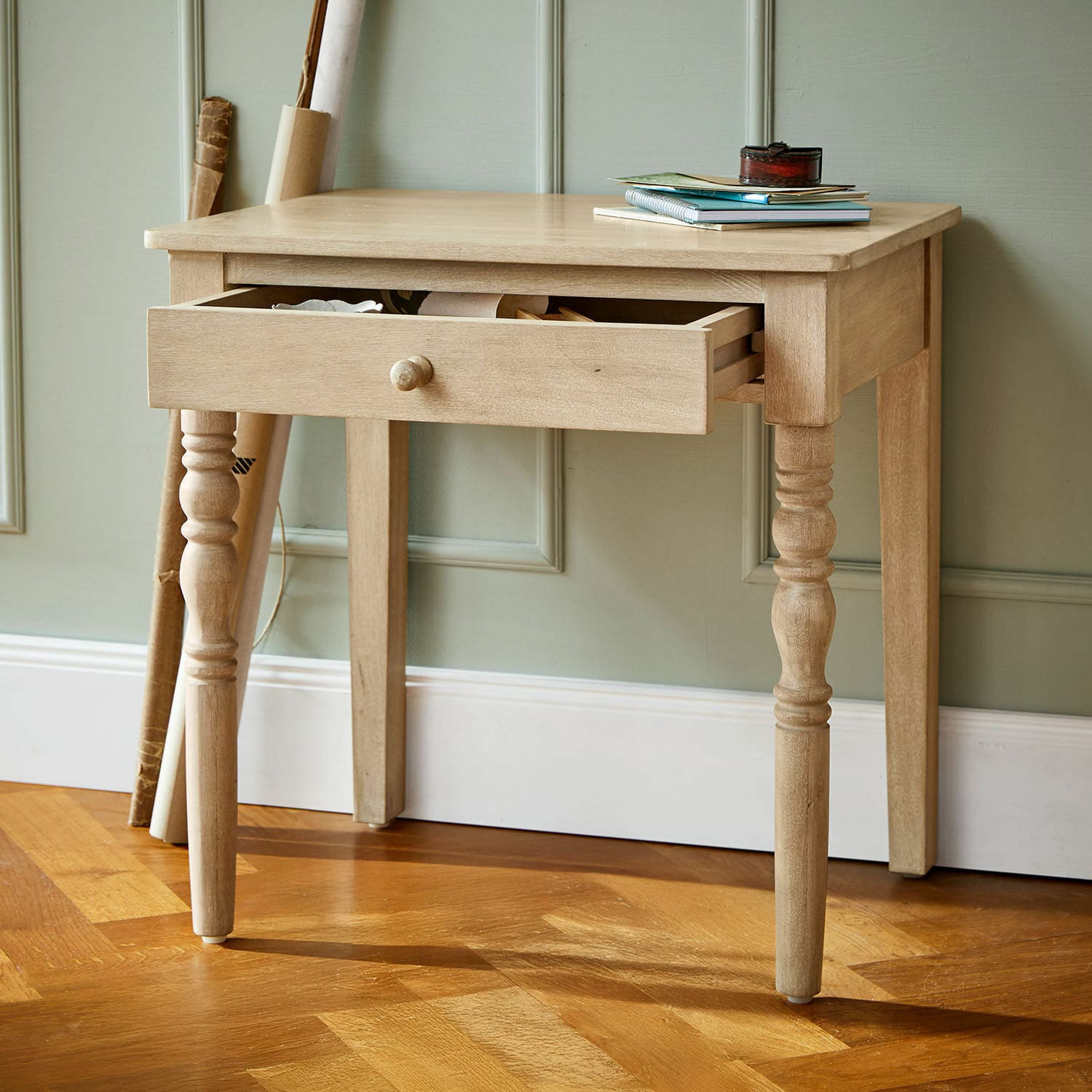 Bureau pour enfant Doucetin Table en bois clair avec tiroir ouvert sur parquet, meuble d'appoint pour salon