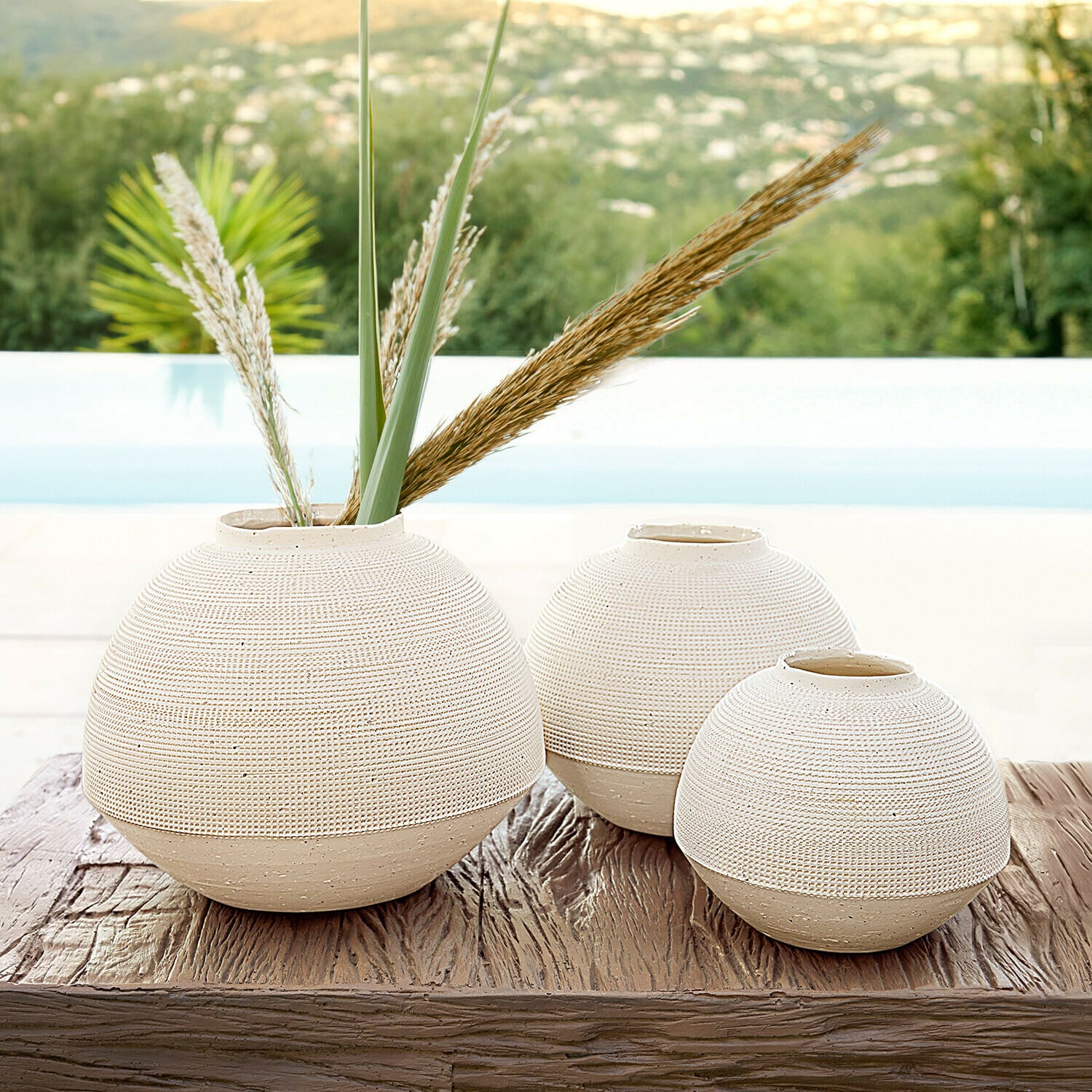 Lot de 3 vases Émoliane Ensemble de trois vases ronds en céramique beige sur une table en bois, décoration intérieure élégante