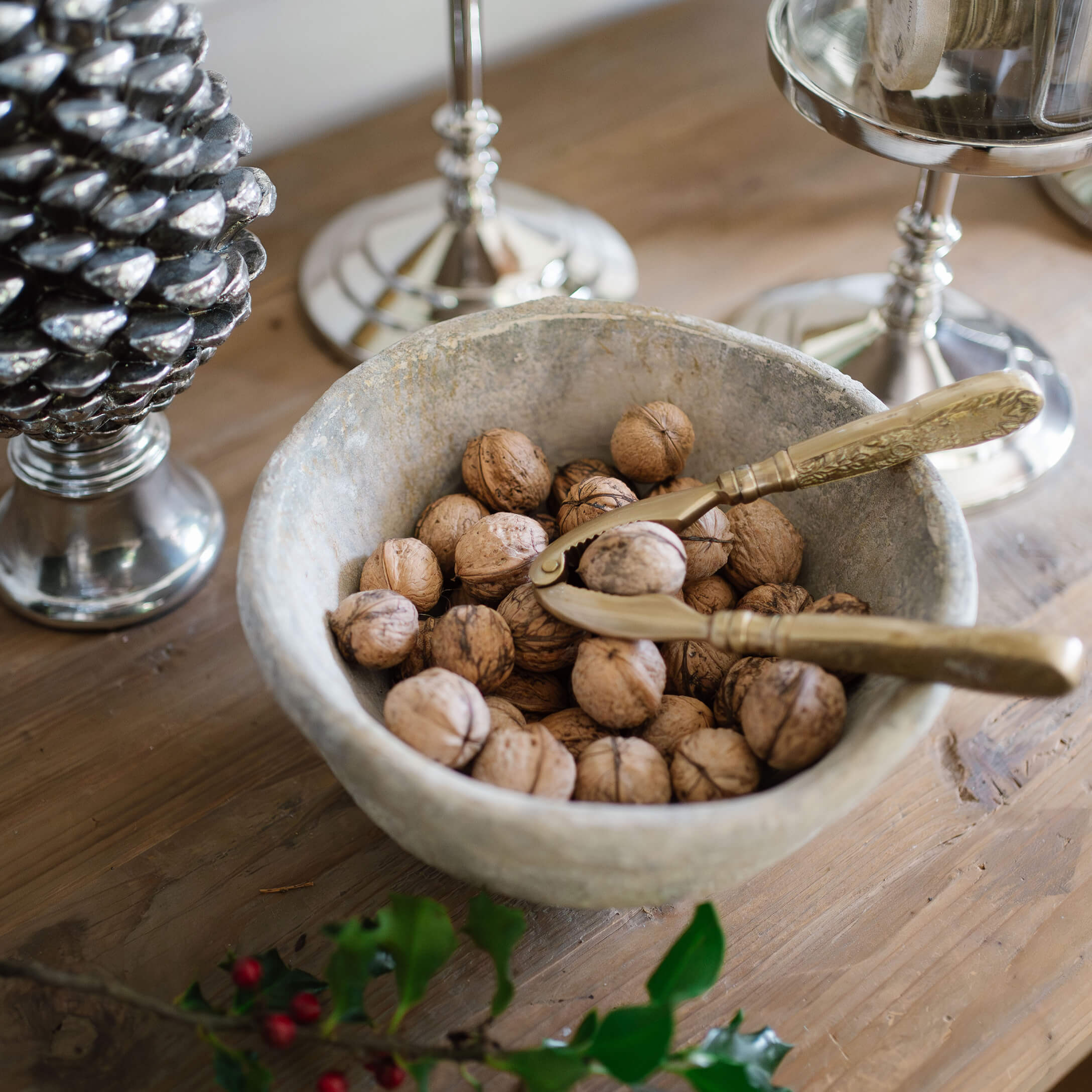 Bol en pierre avec noix et casse-noix doré sur une table en bois rustique