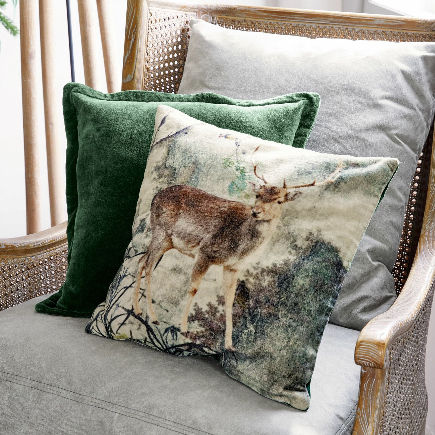 Kussenhoes set van 2 Anie Set decoratieve kussens met hertmotief en groene fluweel op een grijze stoel