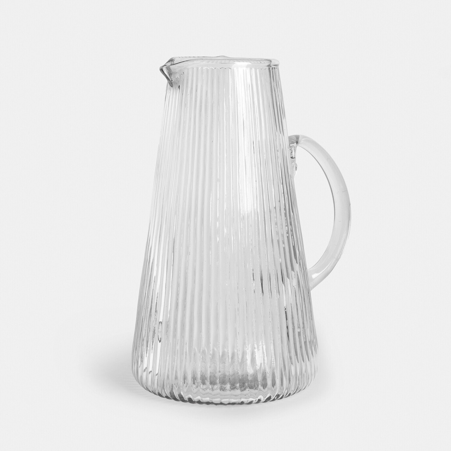 Carafe en verre transparent avec surface cannelée et anse pour servir des boissons