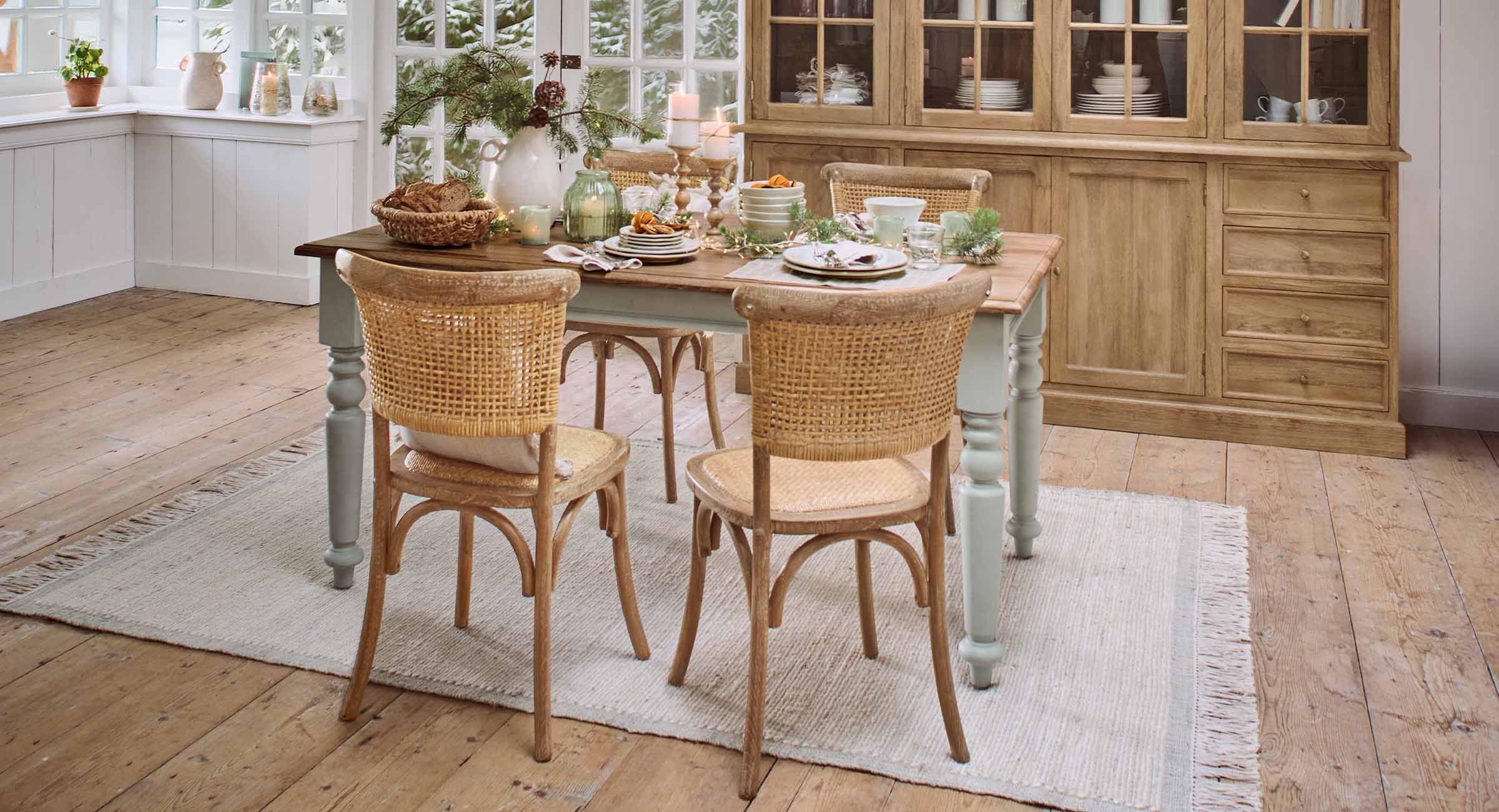 Gezellig adventsontbijt op houten tafel met rotan stoelen en kerstdecoratie