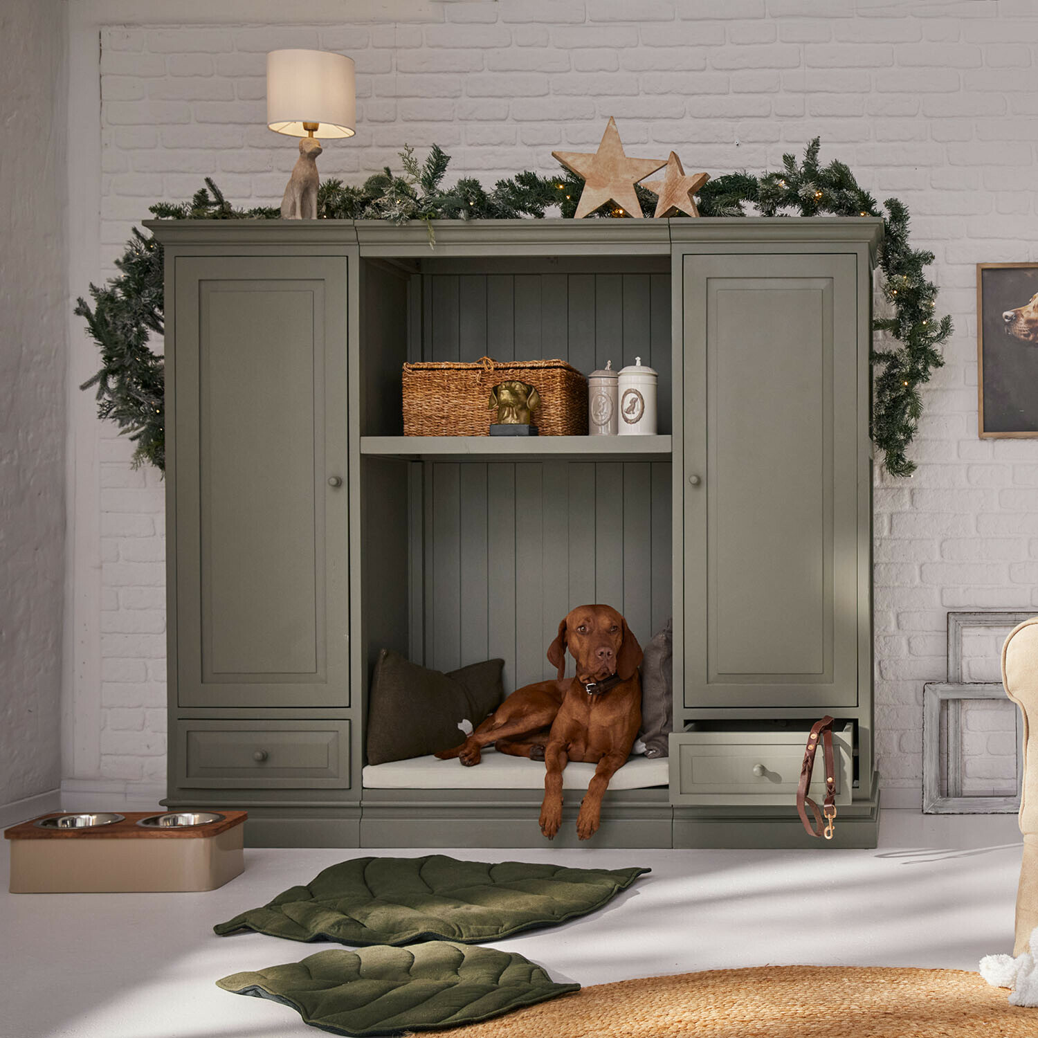 Kast voor huisdieren Stoneleighs Grijze houten kast met hondenplek en kerstdecoratie in lichte woonkamer