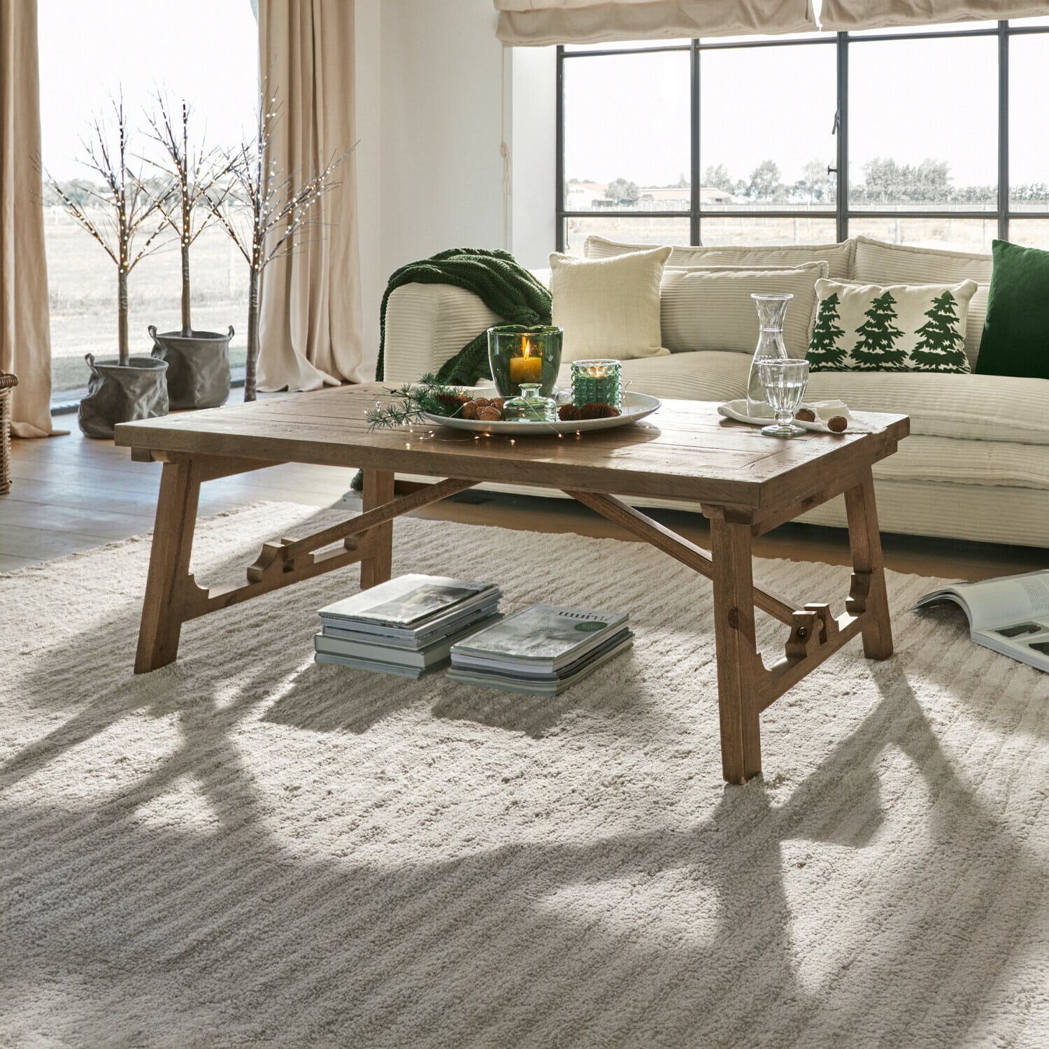 Salontafel Flemming Houten salontafel in natuurlijke kleur op lichte vloerkleed in gezellige woonkamer met groene accenten