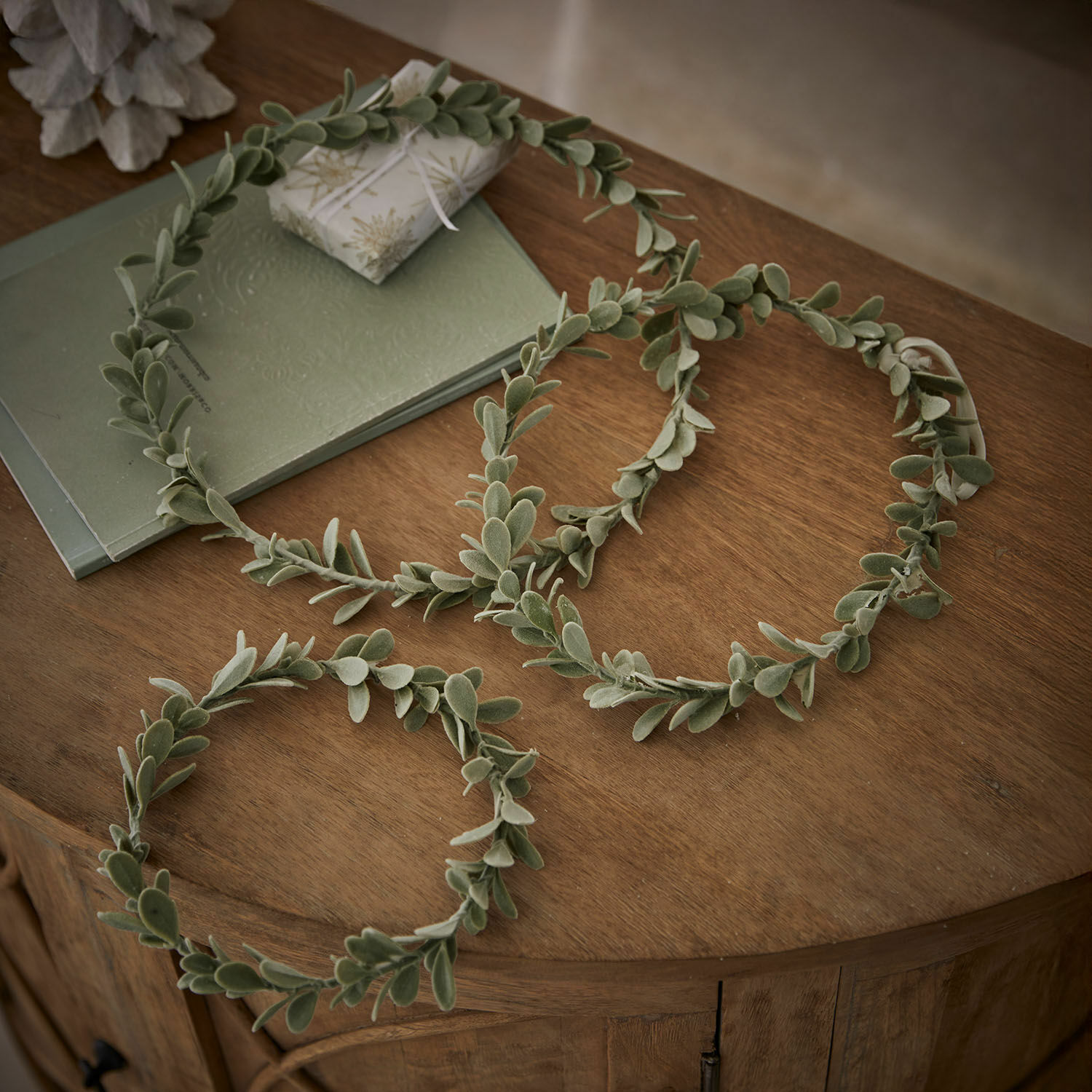 Lot de 3 couronnes Carivela Couronnes décoratives vertes en feuilles douces posées sur une table en bois, décoration naturelle