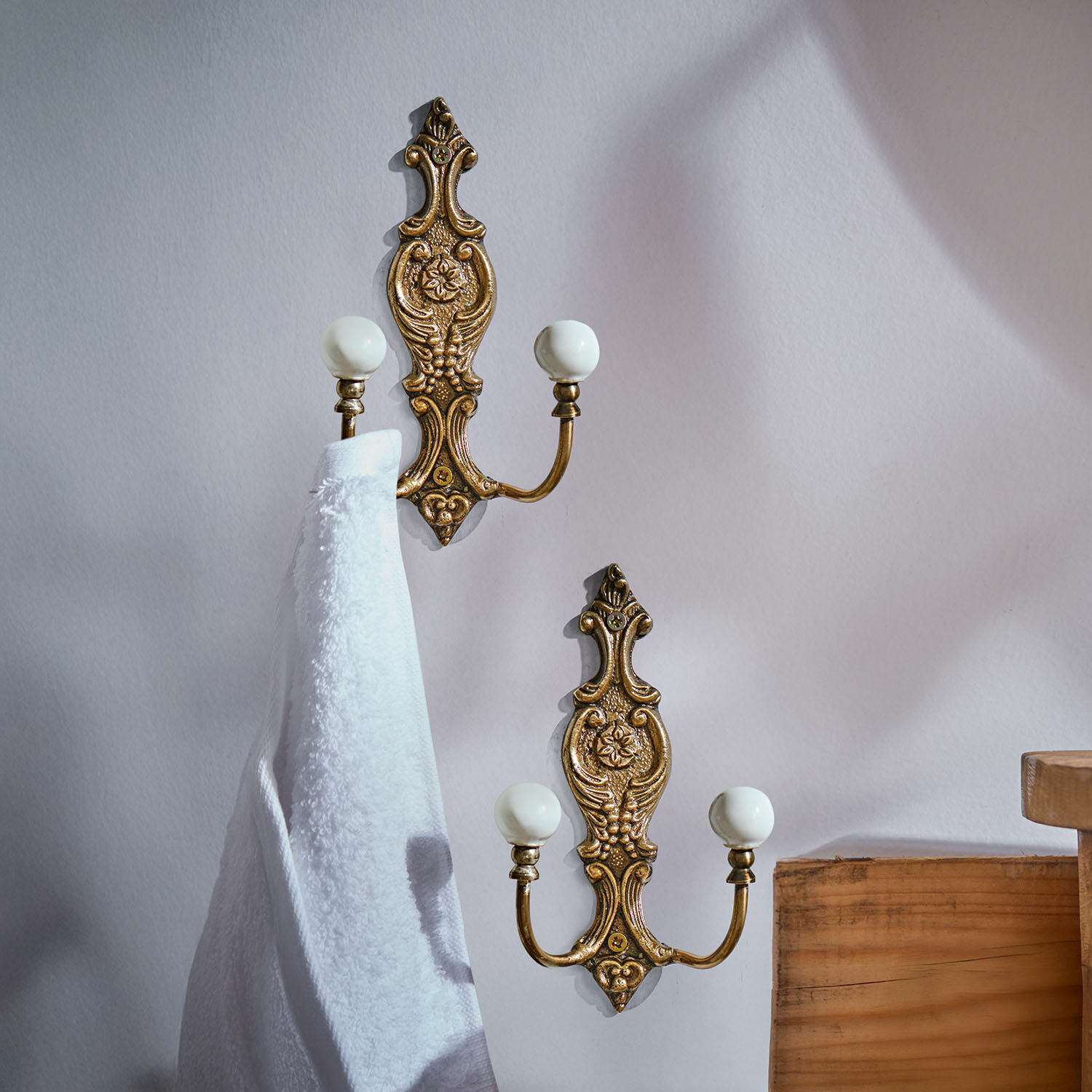 Haak set van 2 Nuvéal Set van twee messing wandhaken met witte keramische knoppen en decoratief patroon