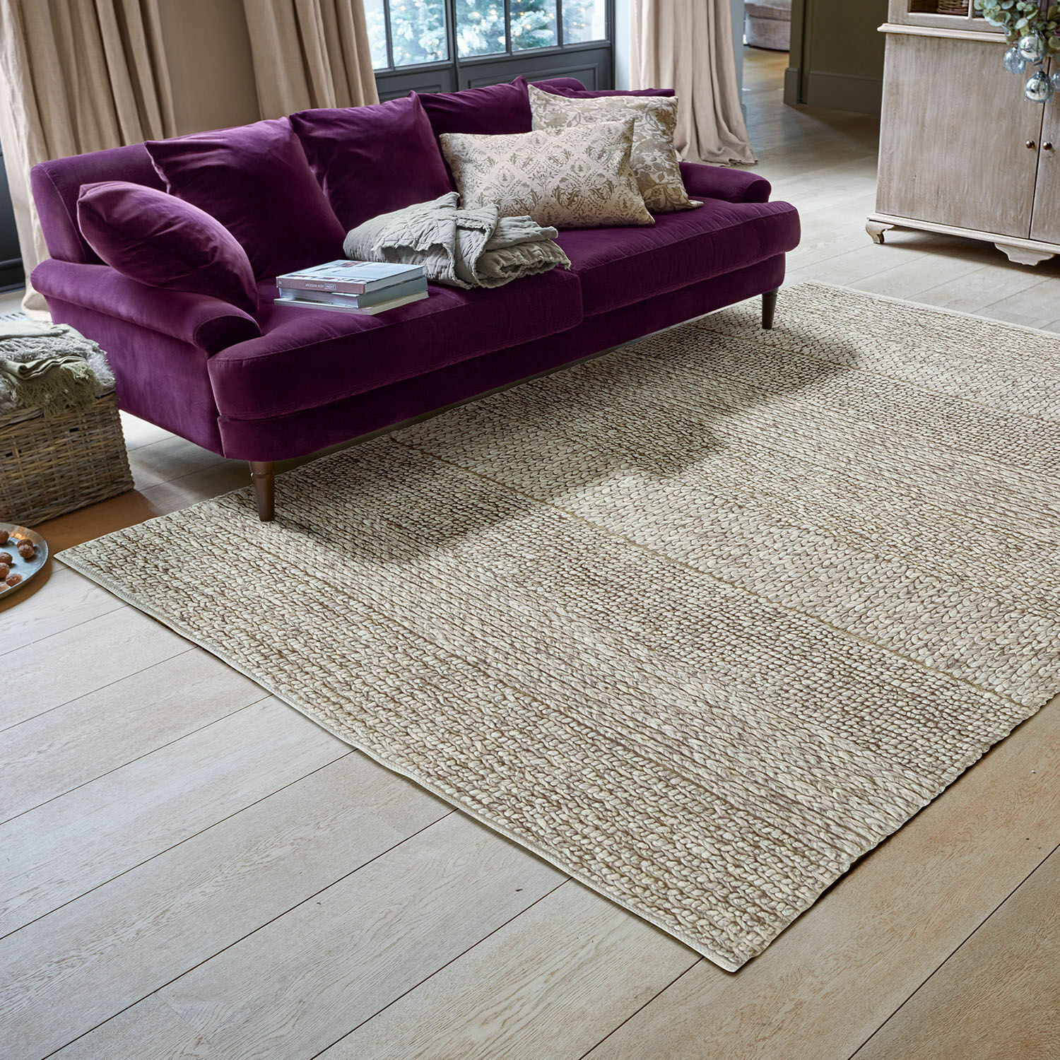 Vloerkleed Welezas Beige vloerkleed van natuurlijk materiaal met gevlochten structuur in moderne woonkamer met paarse bank