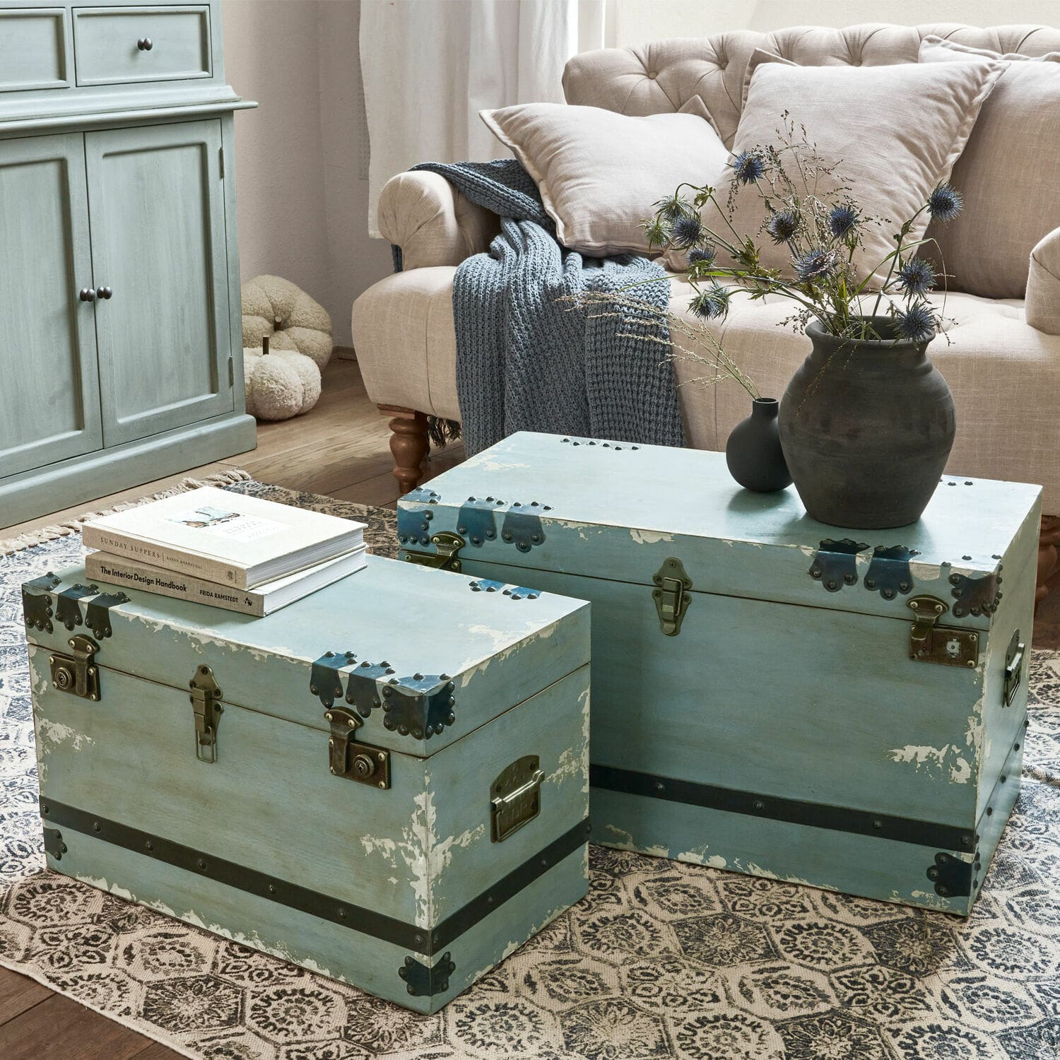 Kist set van 2 Gorman Twee blauwe houten kisten met metalen beslag op tapijt in woonkamer met beige bank