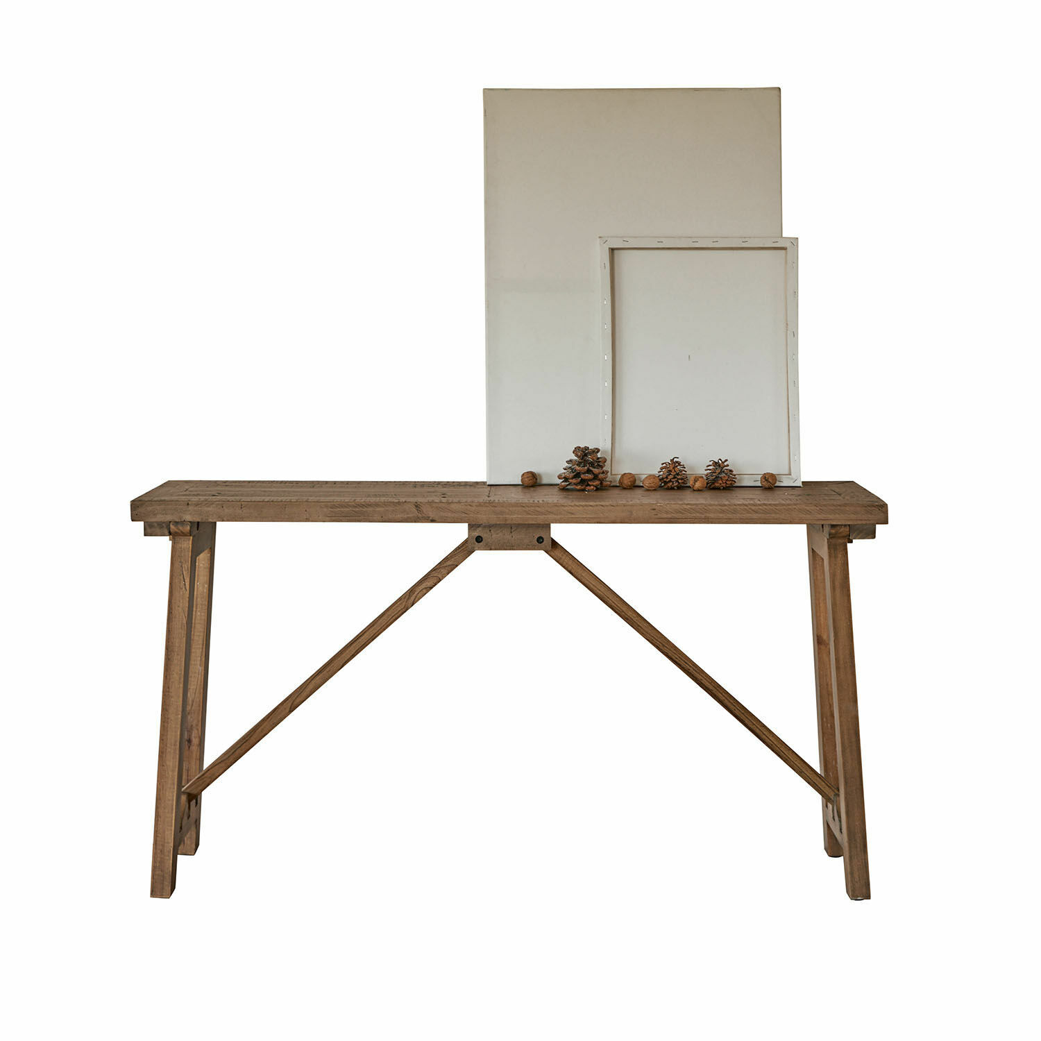 Console Flemming Table en bois naturel avec décoration de pommes de pin et cadres blancs vides posés dessus