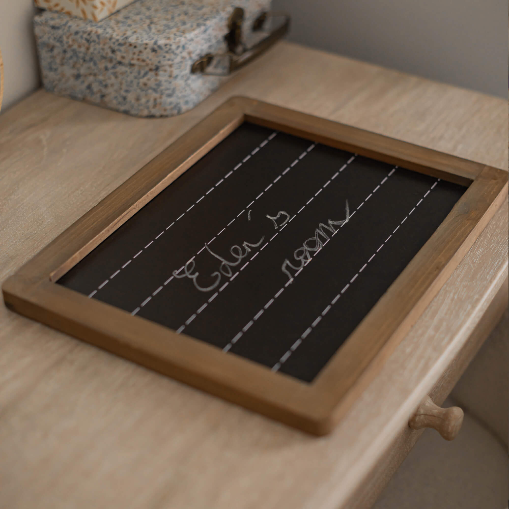 Tableau noir avec cadre en bois sur une table en bois clair, décoration intérieure
