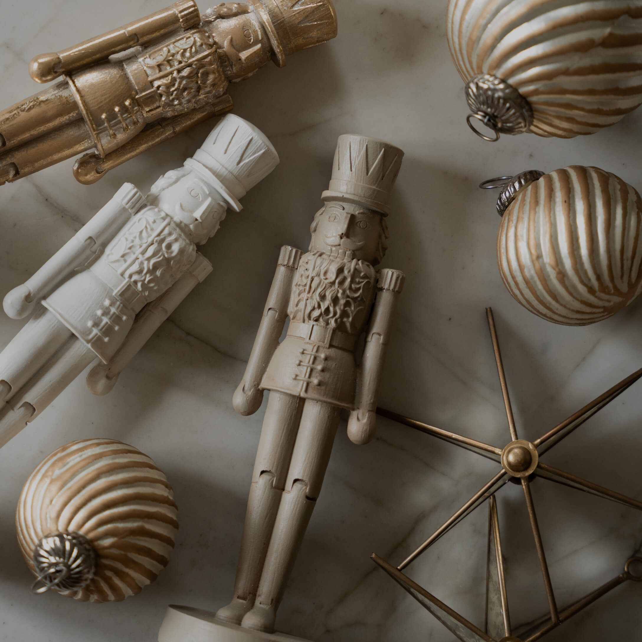Figurines en bois de soldats et boules de Noël dorées sur fond en marbre, décorations festives