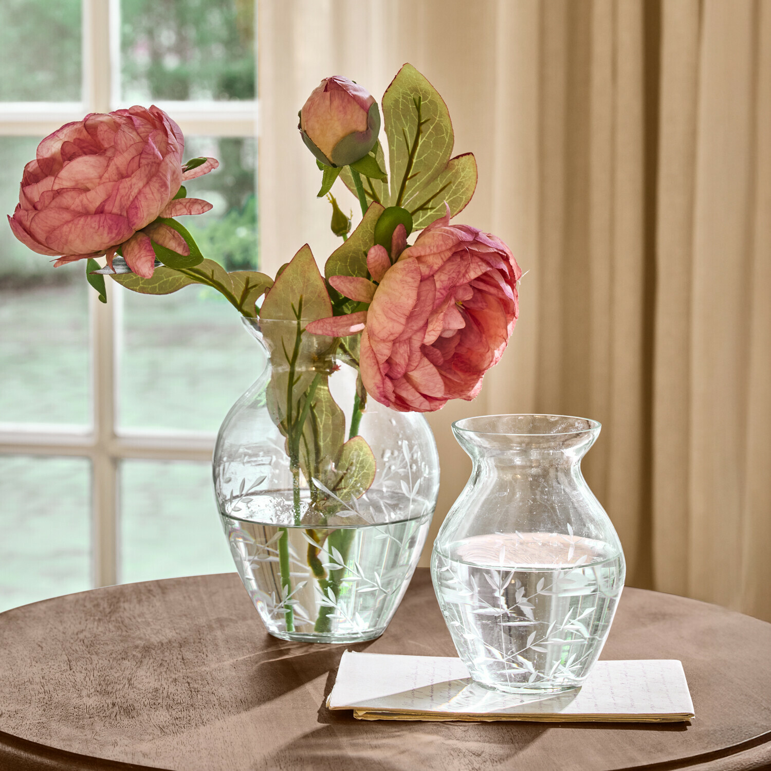 Lot de 2 vases Paimpont Vases en verre transparent avec motif gravé de feuilles, l'un avec des fleurs roses, sur une table en bois
