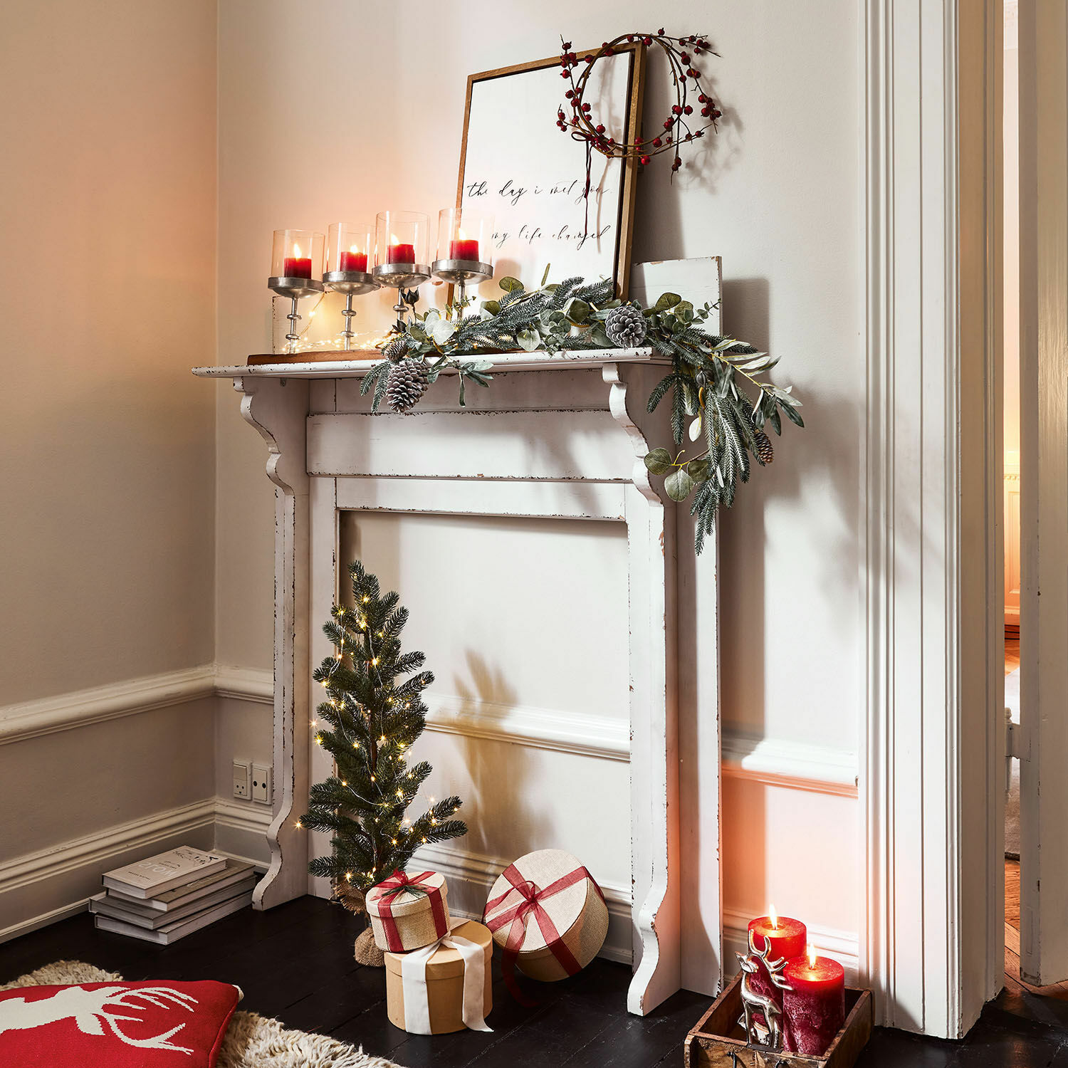 Haardschouw Cessieu Witte decoratieve houten schouw met groene krans, rode kaarsen en kerstcadeaus
