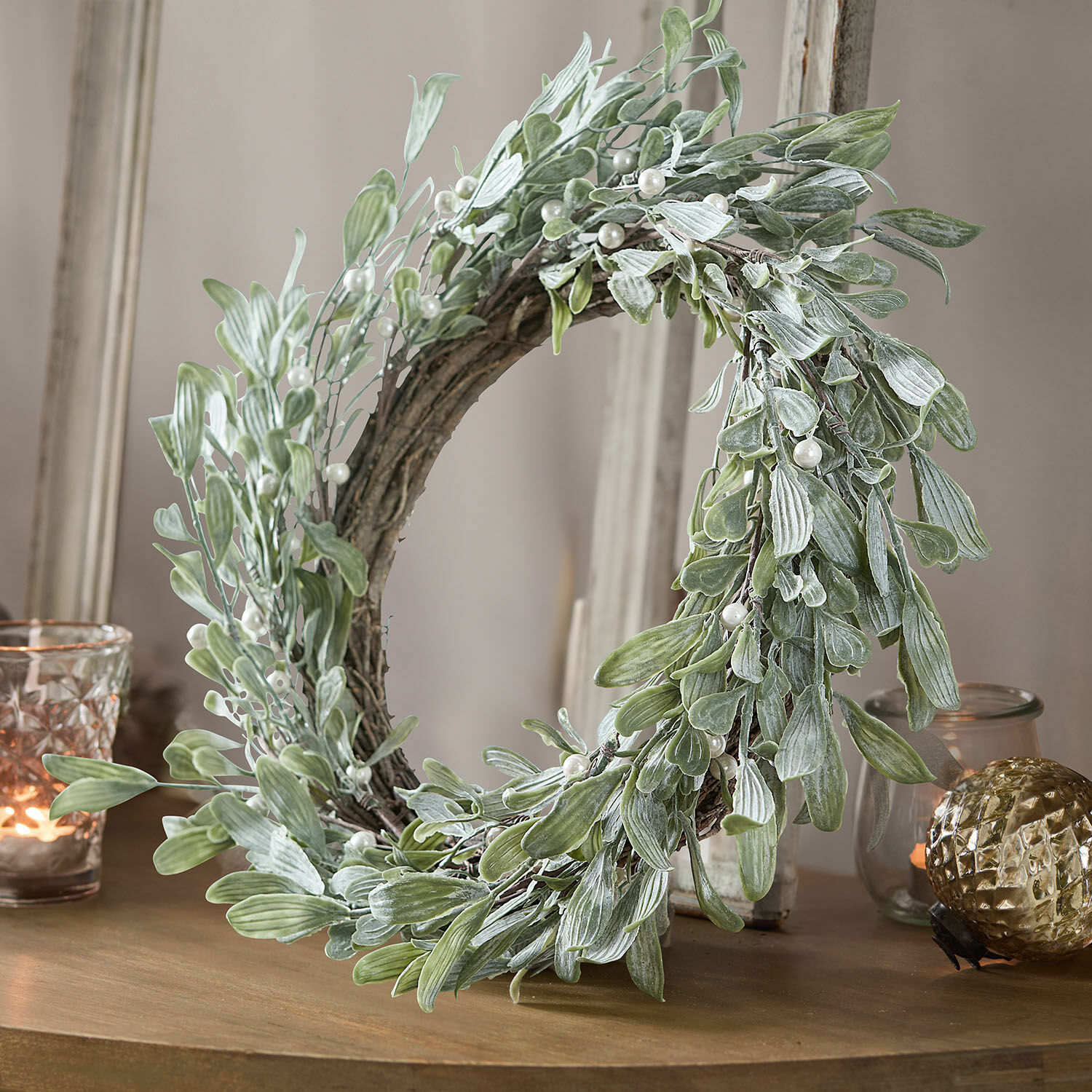 Krans Cunnig Decoratieve krans met groene bladeren en parels op houten tafel, interieurdecoratie