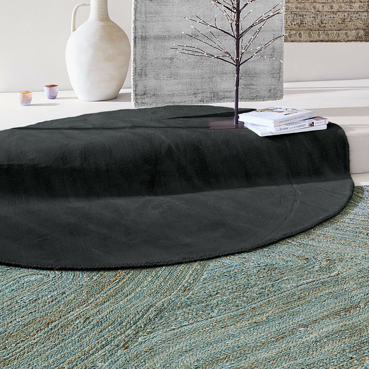 Tapis Mariselle Tapis rond noir en tissu doux dans un intérieur clair avec décorations et livres posés dessus