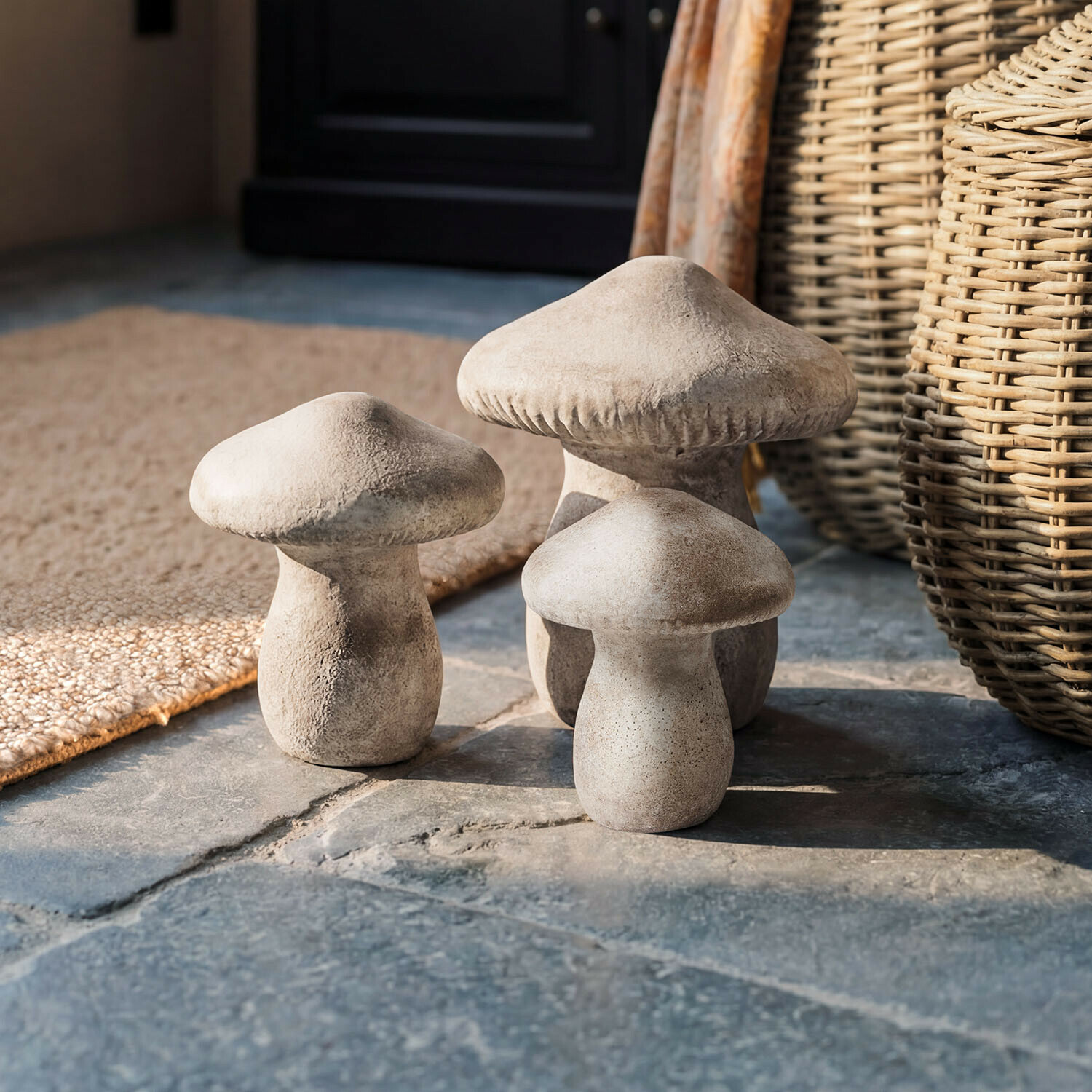 Paddenstoel set van 3 Rynmor Drie decoratieve betonnen paddenstoelen in natuurlijke kleur op een rustieke stenen vloer