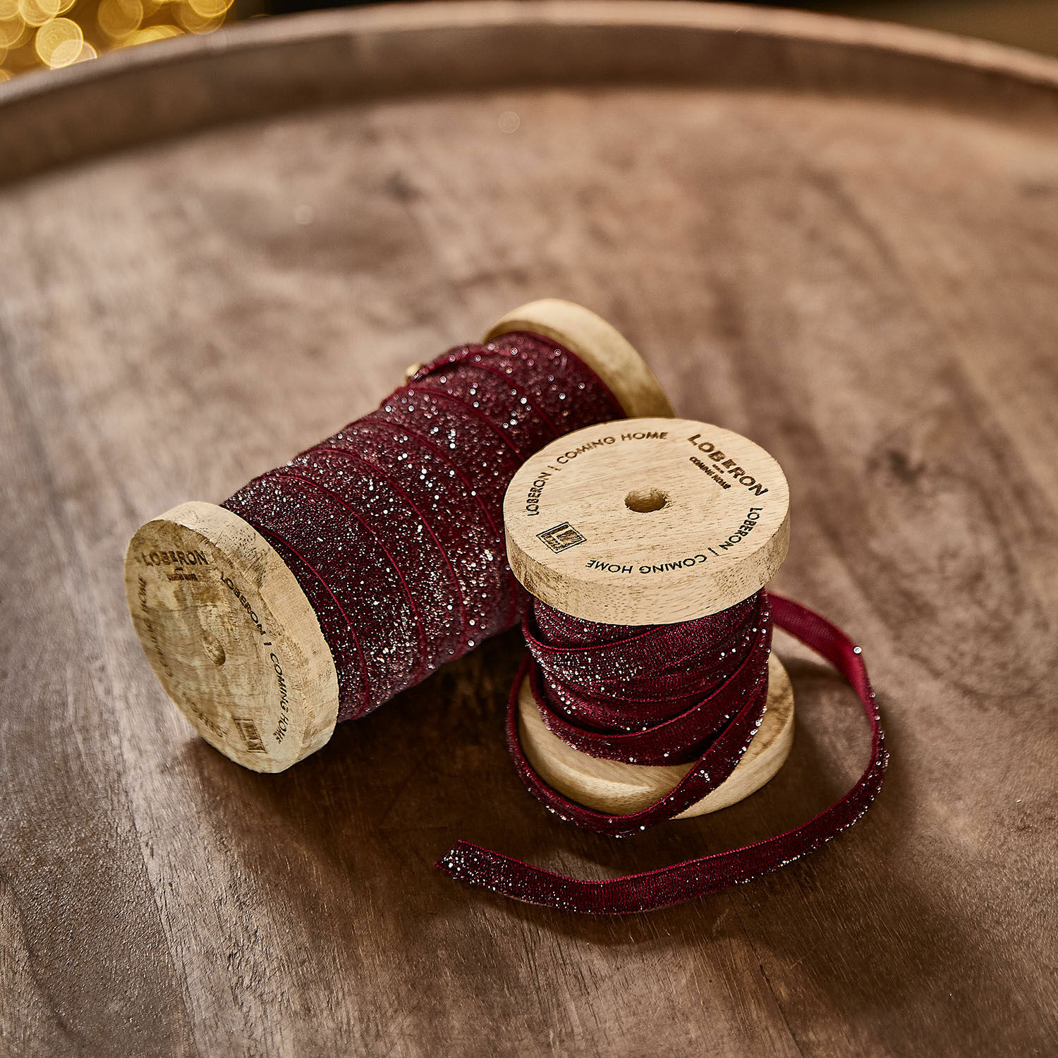Fluwelen lint set van 2 Risorio Bordeaux glinsterlint op houten spoelen op houten tafel voor decoratie en knutselen